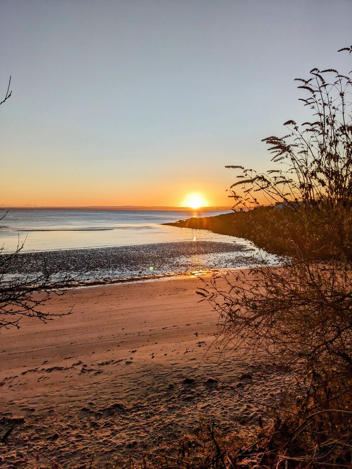 A golden sunset over the beach and the Firth of Forth at Aberdour.