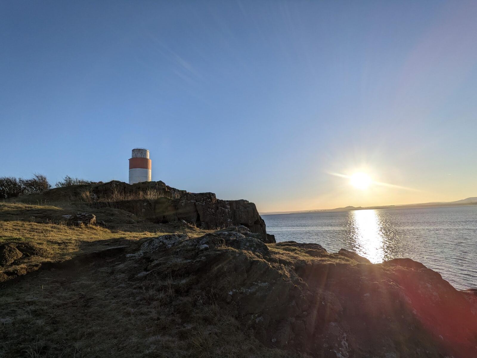 The beacon on Hawkcraig Point at Aberdour with the sun setting over the Forth.