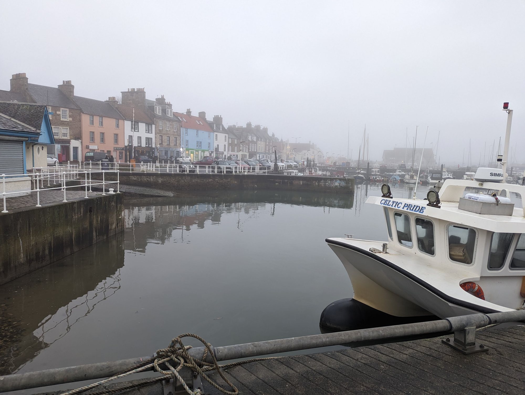 Anstruther harbour and its painted houses on a still afternoon.