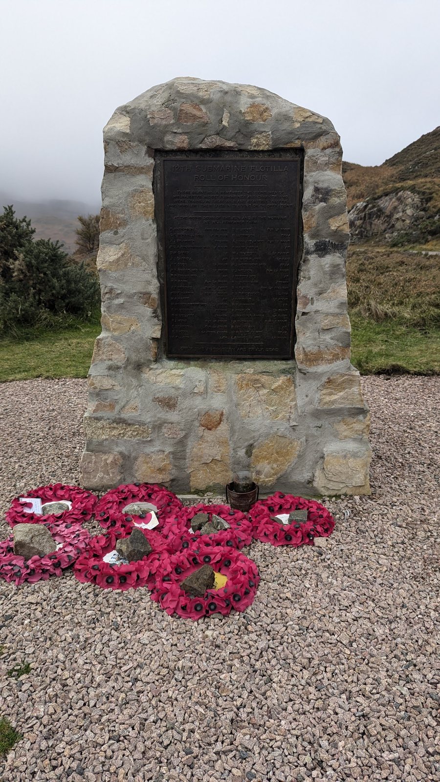 The XII Submarine Flotilla war memorial at Kylesku, poppy wreaths at its foot.