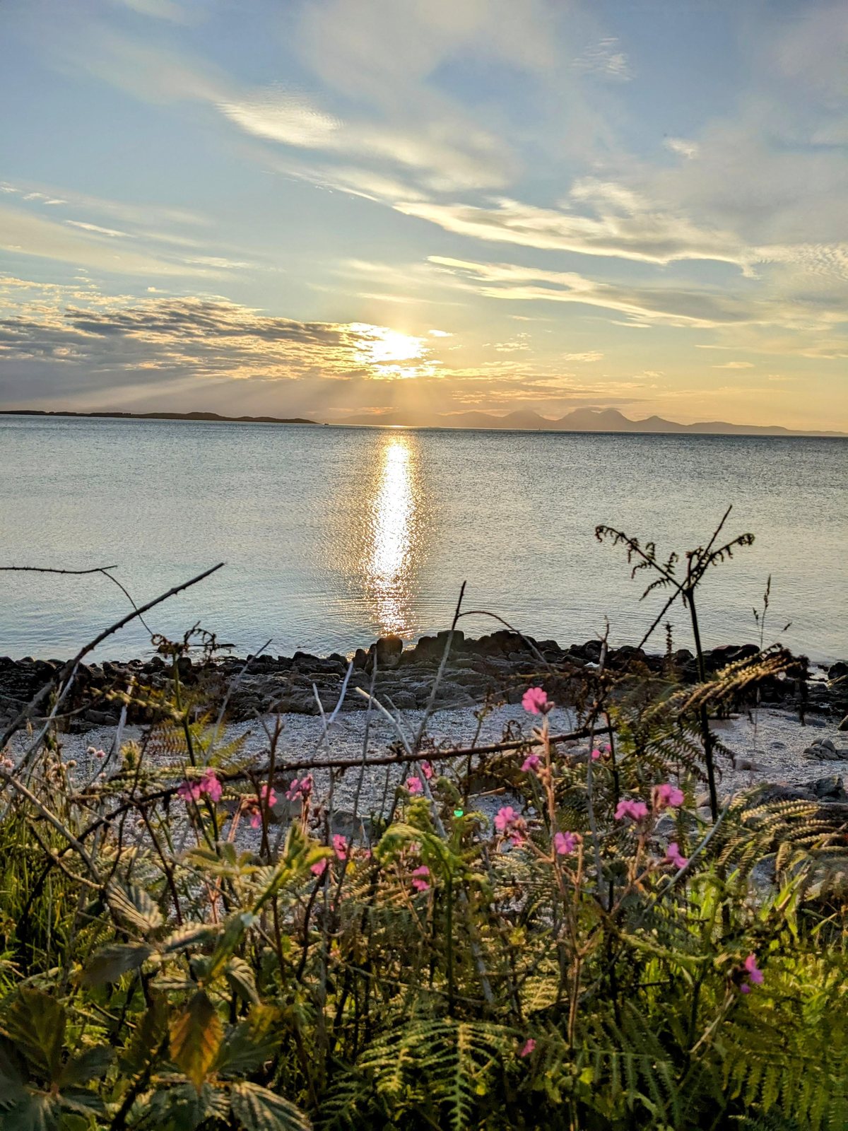 The sun setting over the sea and islands at Ballochroy.