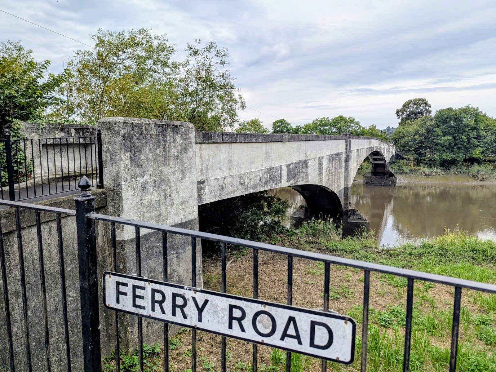 A street sign reading Ferry Road with the footbridge over the River Forth behind it, Cambuskenneth.