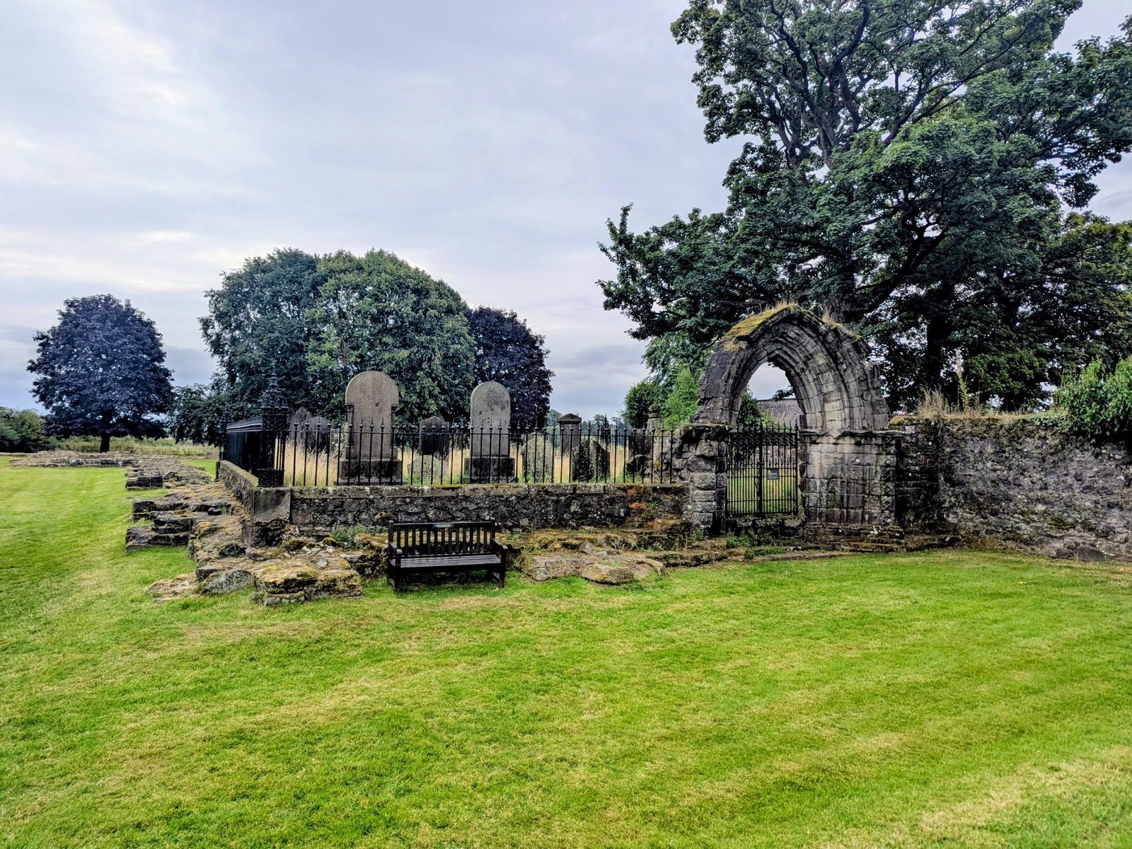 The old burial ground beside Cambuskenneth Abbey tower with a surviving fragment of stonework.
