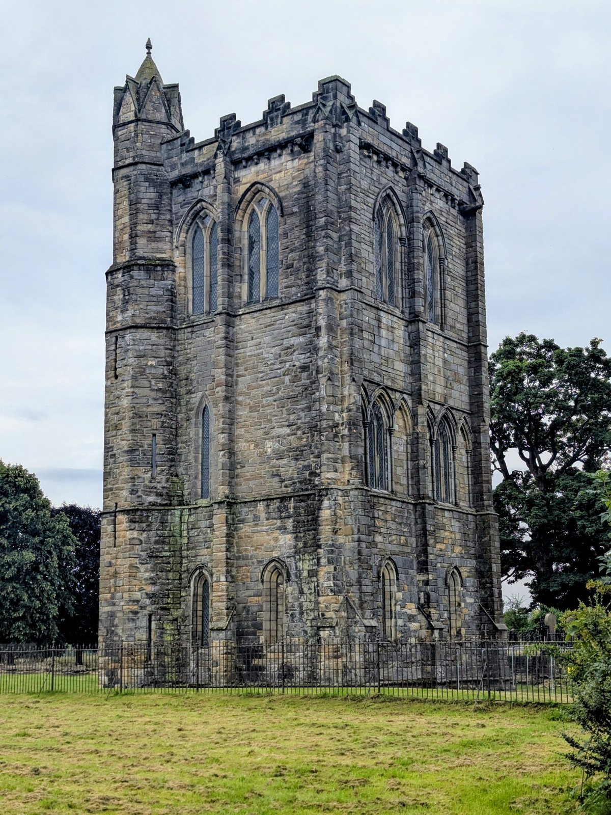 Close view of the dressed-stone corner and lancet windows of Cambuskenneth Abbey tower.