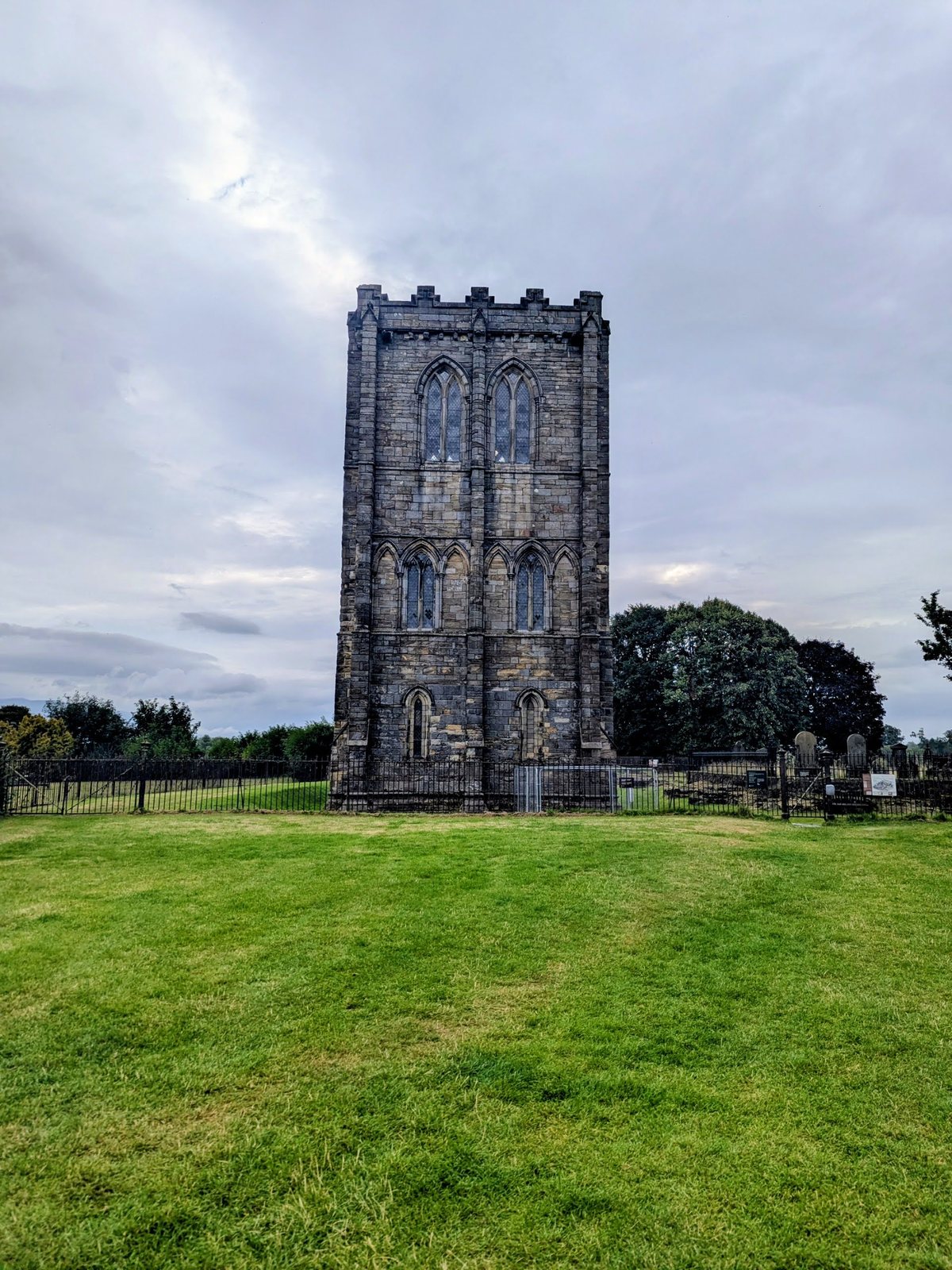 The bell tower of Cambuskenneth Abbey against a cloudy sky.