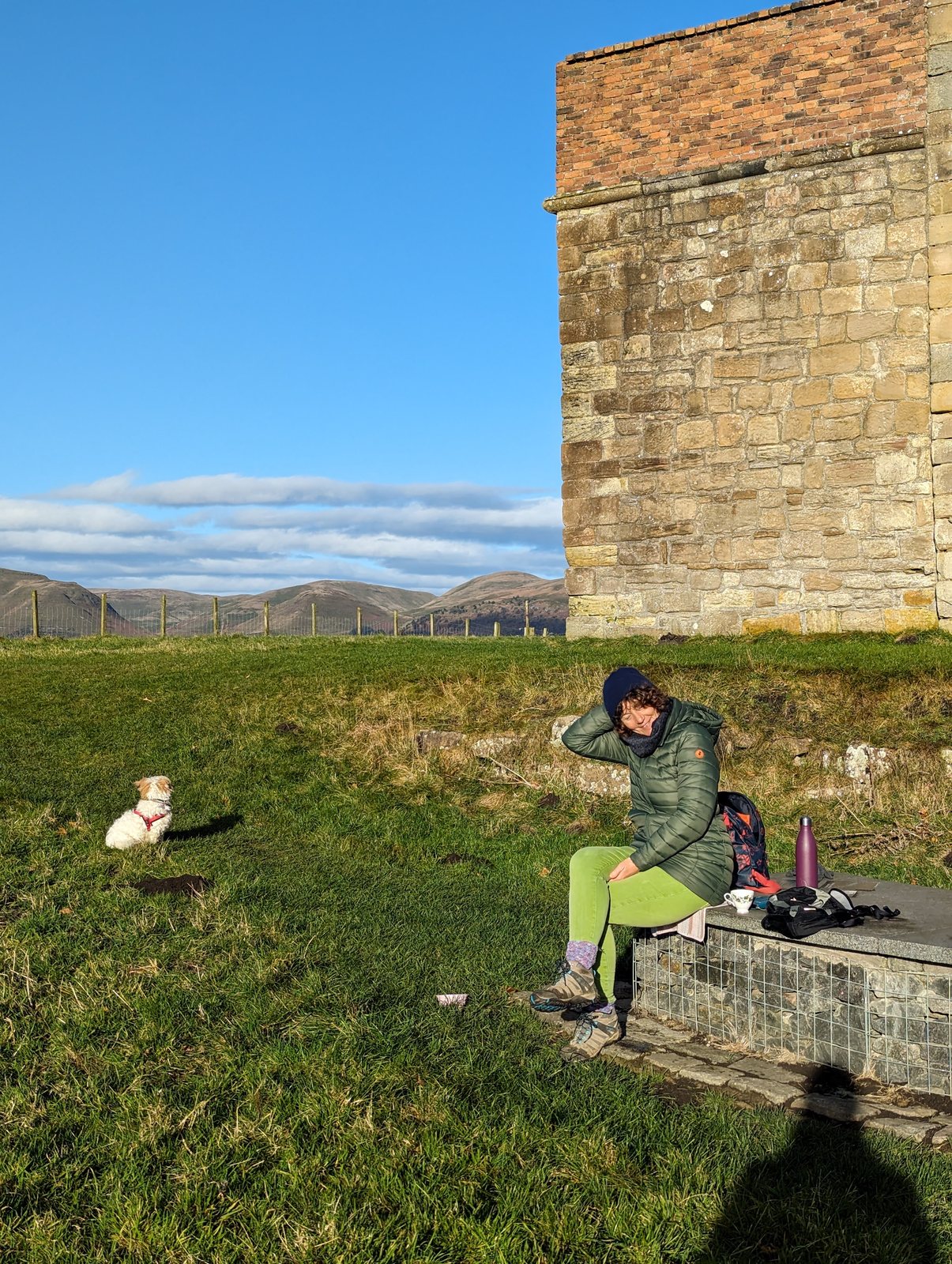 Clackmannan Tower on the grassy hilltop with visitors below.