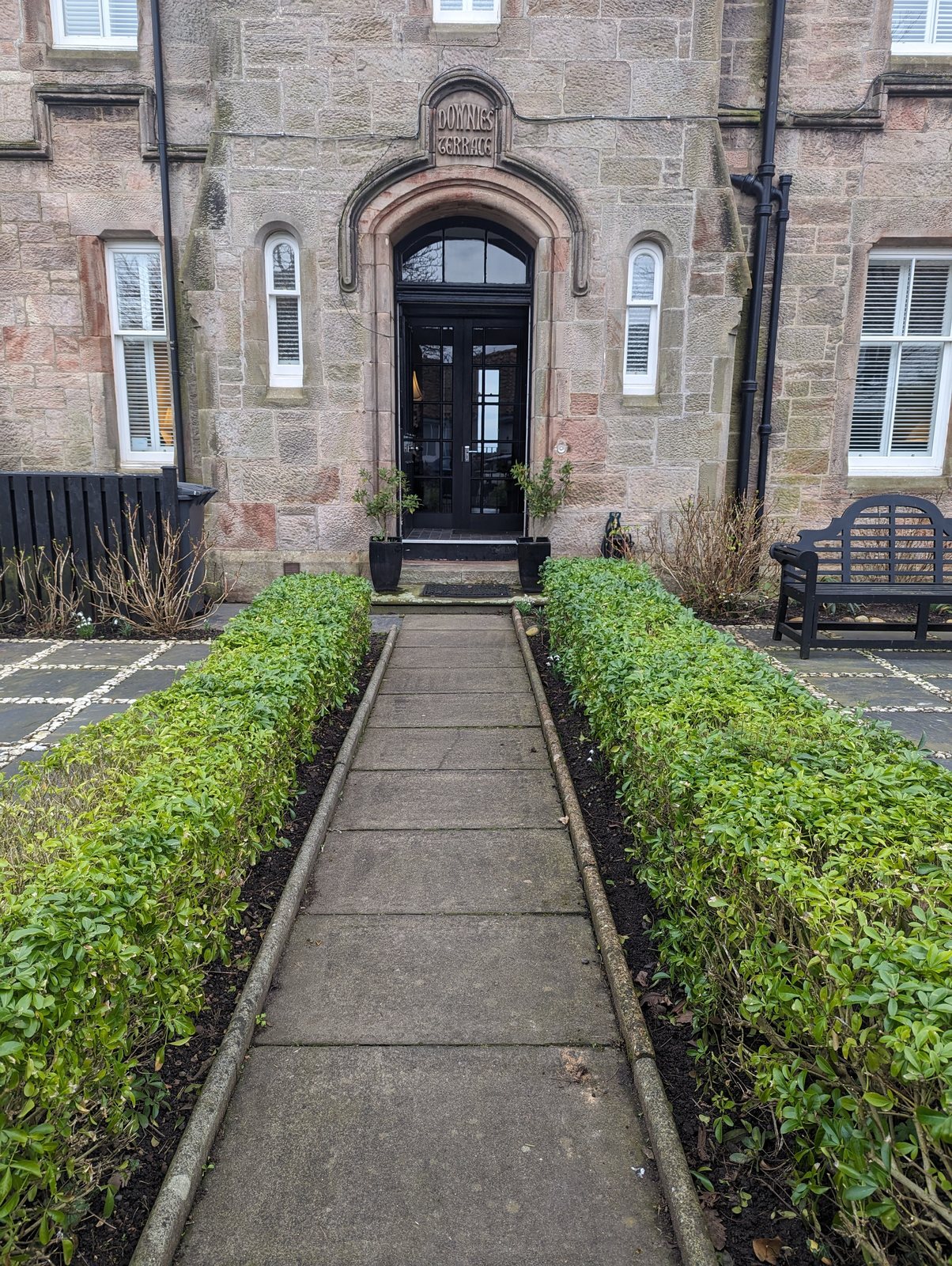 An old arched merchant&rsquo;s doorway with a hedged path in Crail.