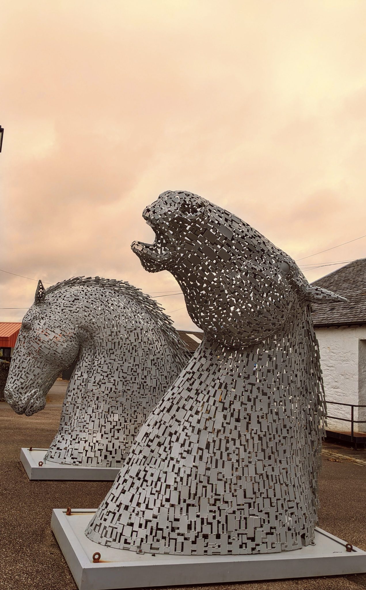 One of the Wee Kelpie horse-head sculptures at Ardrishaig silhouetted against a fiery dawn sky.