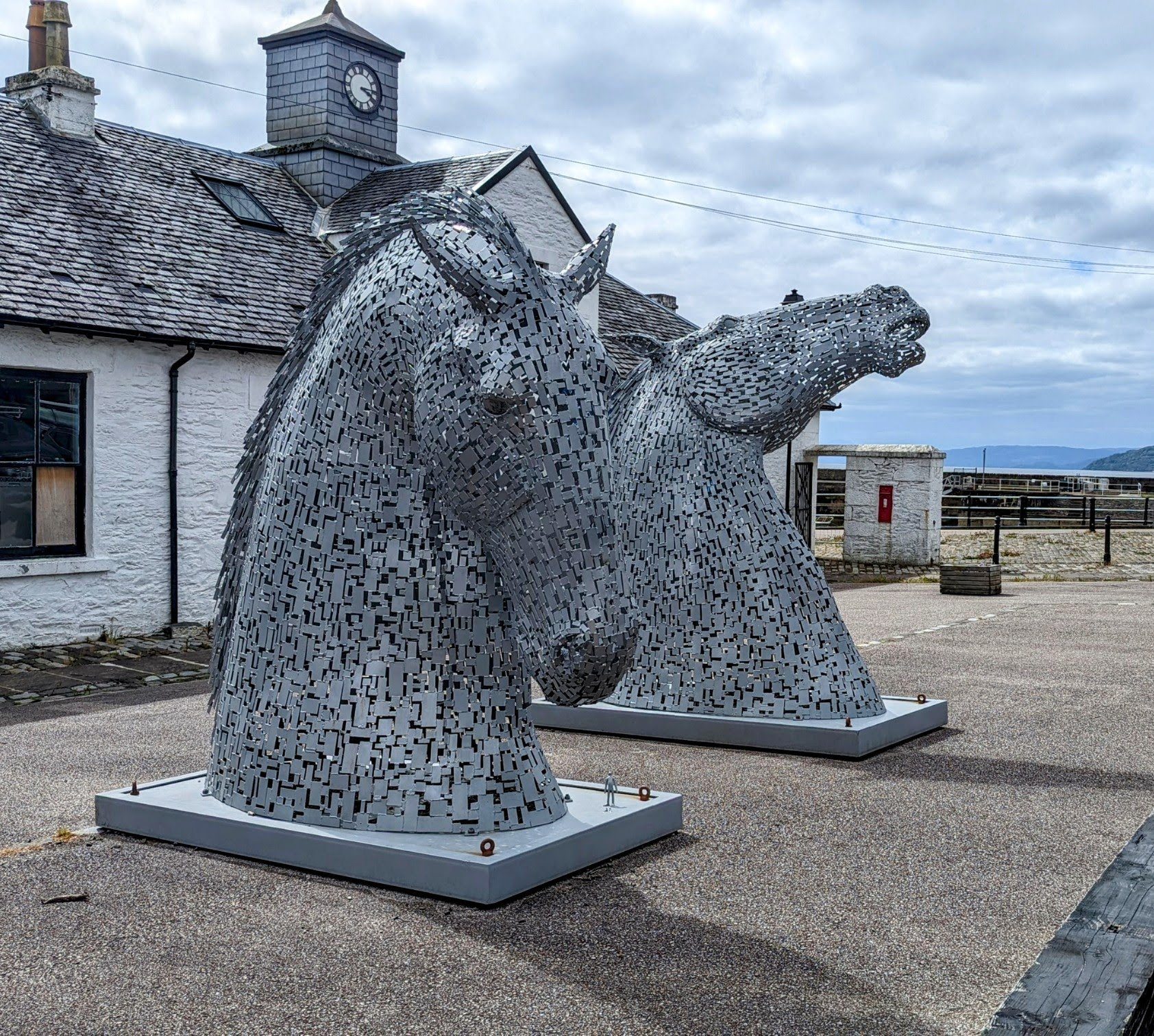 The pair of Wee Kelpie sculptures beside a building at the Ardrishaig end of the Crinan Canal.