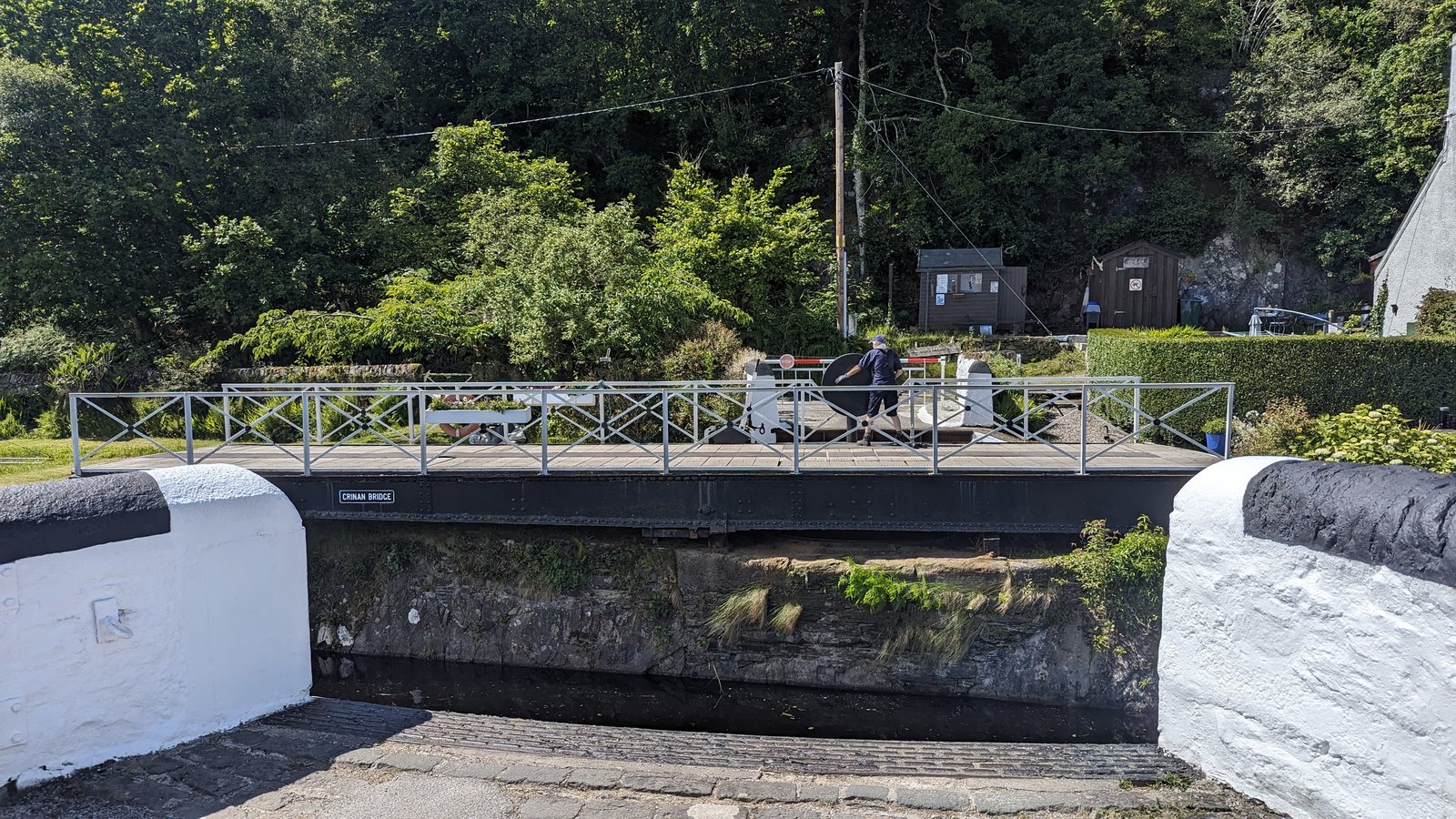 A yacht by the sea lock at Crinan, hills beyond.