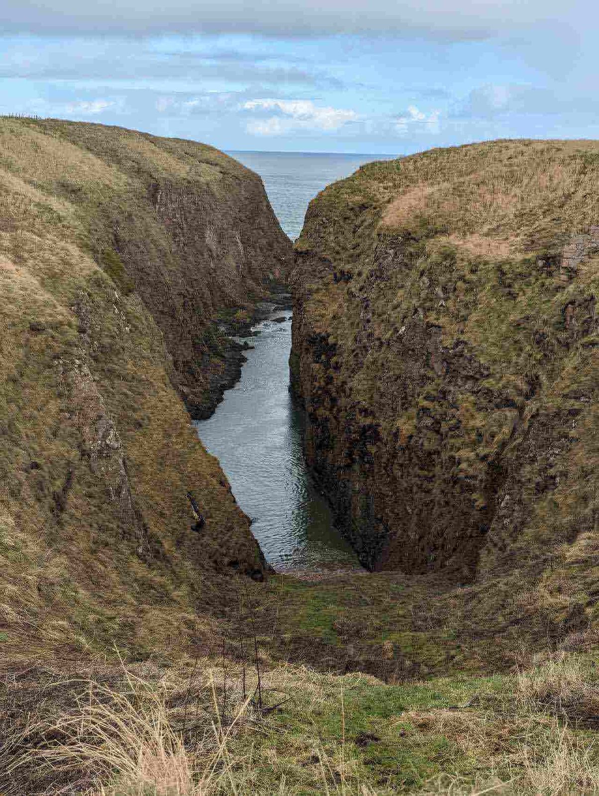 A deep rocky geo cut into the cliffs on the Cruden Bay coast.