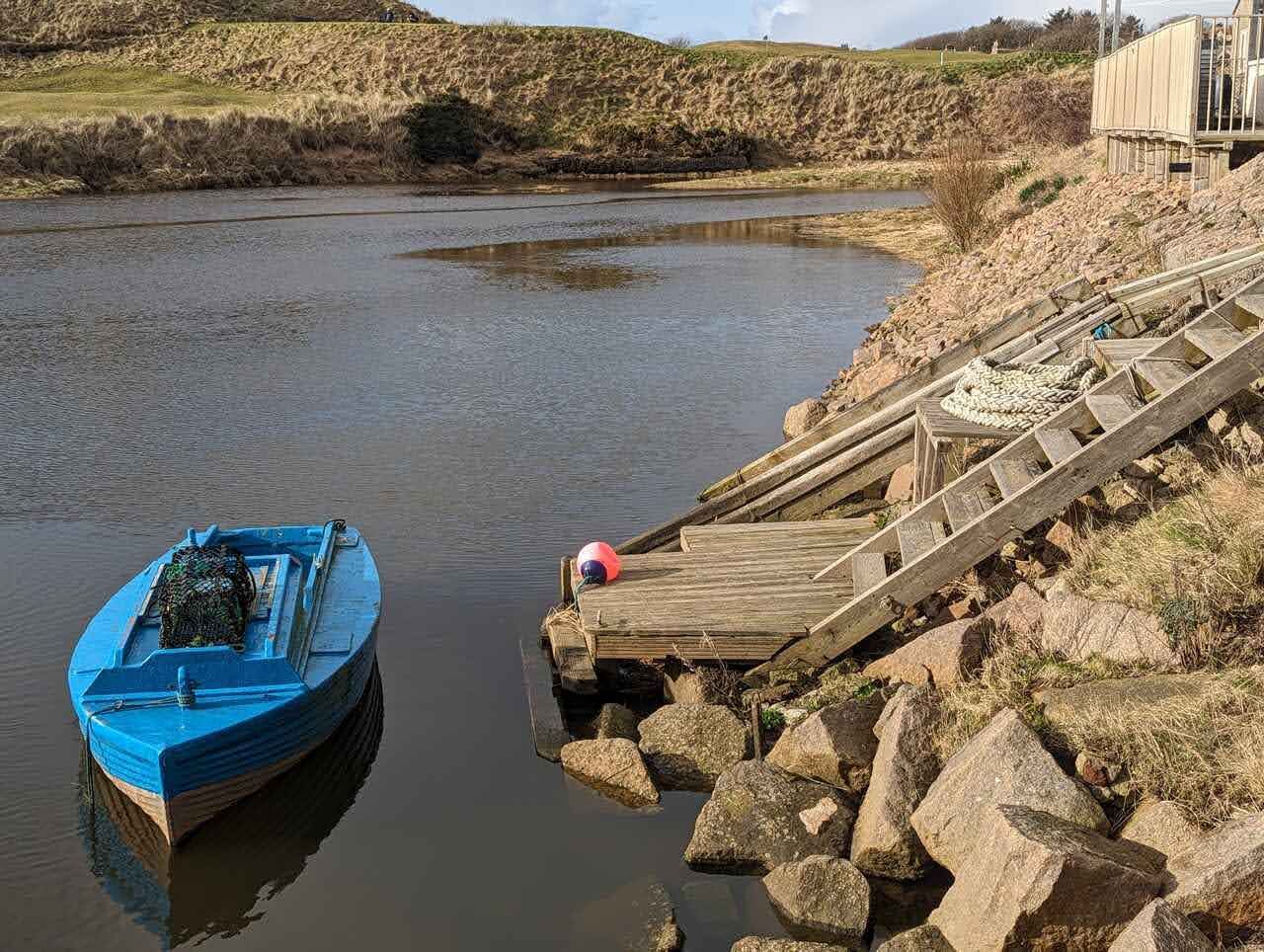 A blue fishing boat in the little harbour at Port Erroll, Cruden Bay.