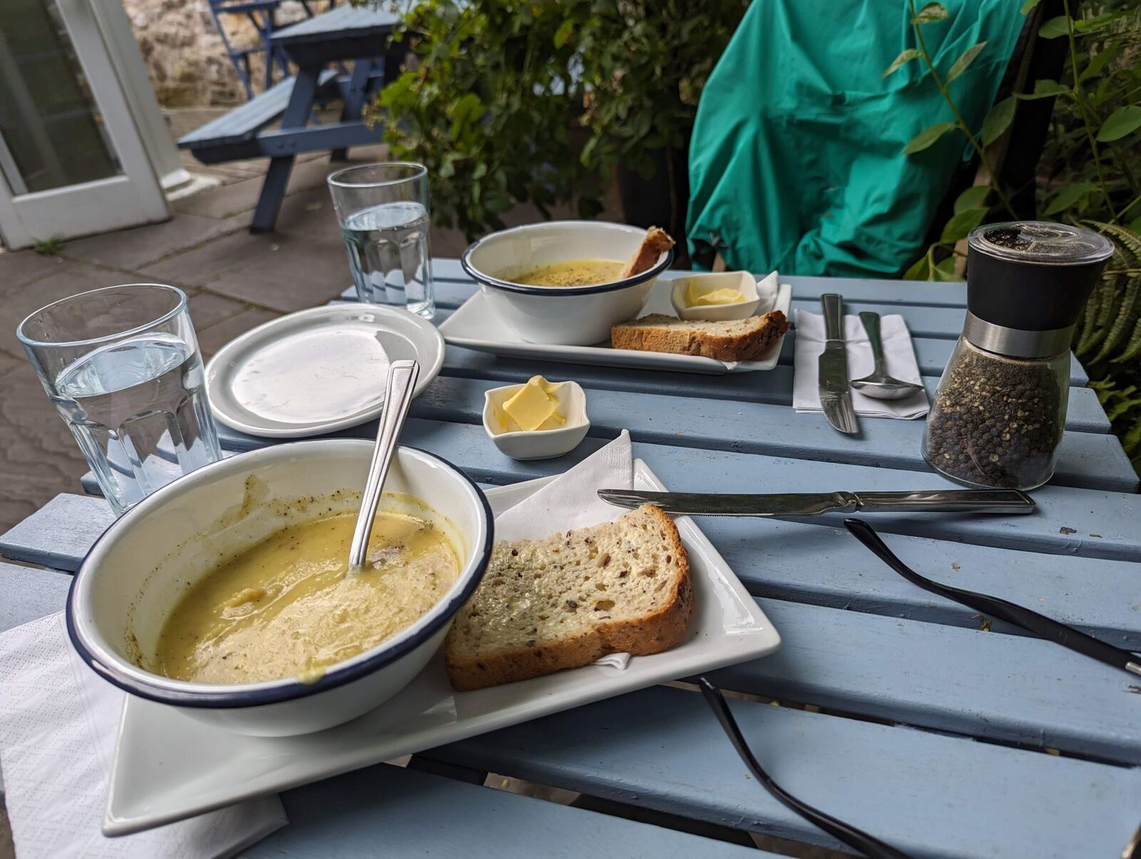 Bowls of soup and bread on a café table with a view over Culross rooftops to the Forth.