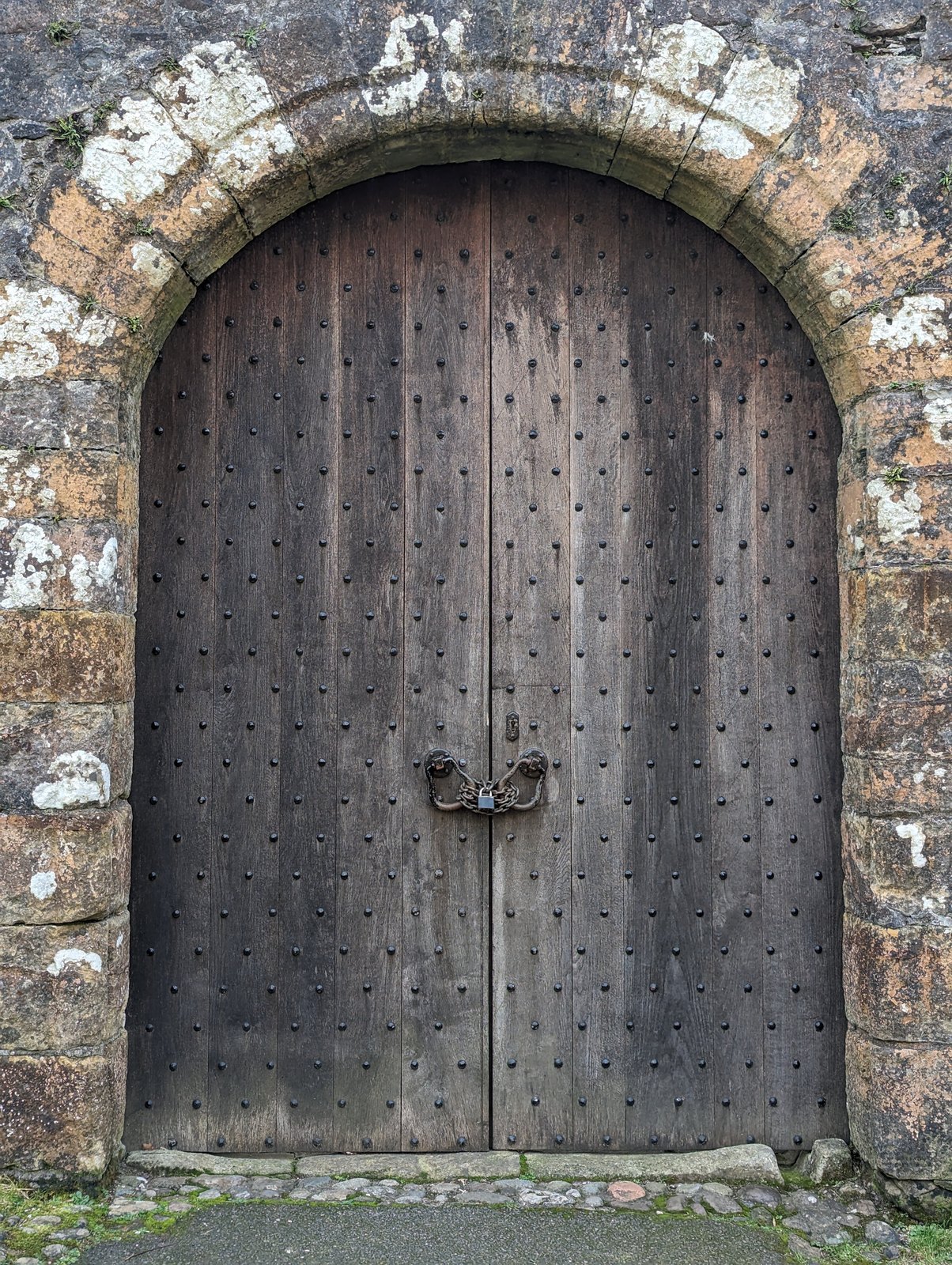 The arched wooden entrance door of Castle Campbell.