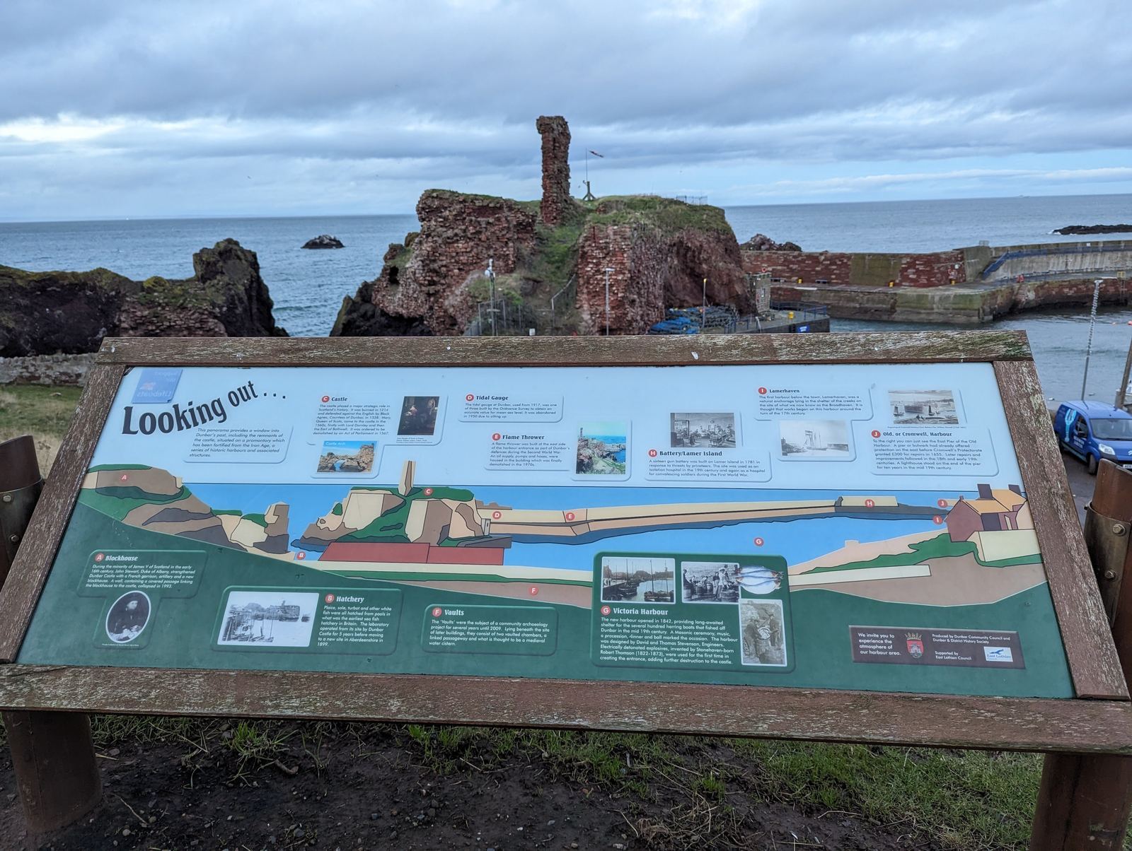 The red ruins of Dunbar Castle standing over the sea.
