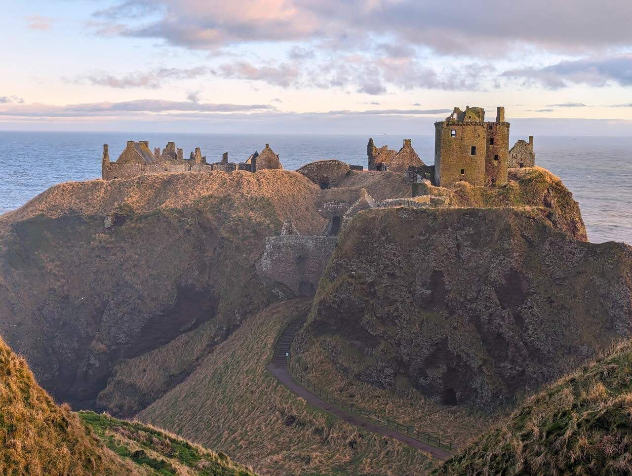 The keep and curtain walls of Dunnottar Castle in low winter light.