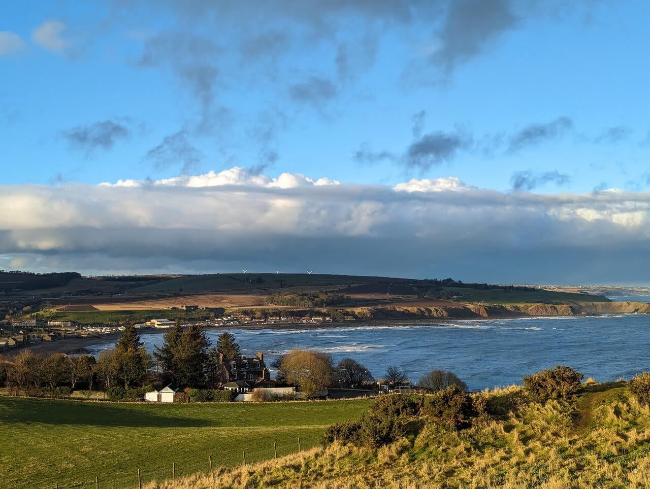 The view over fields and the Aberdeenshire coast from the memorial hill.