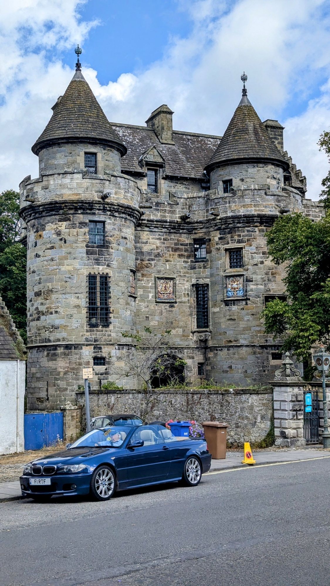 The twin-towered gatehouse of Falkland Palace rising over the village street.