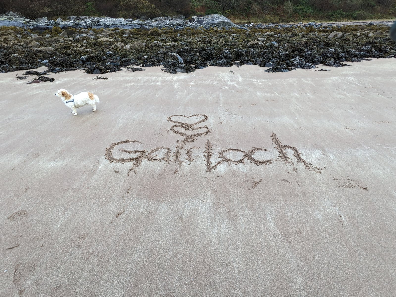 The word Gairloch written in the sand on the beach.