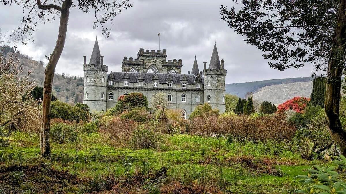 Inveraray Castle glimpsed through bare trees and autumn colour