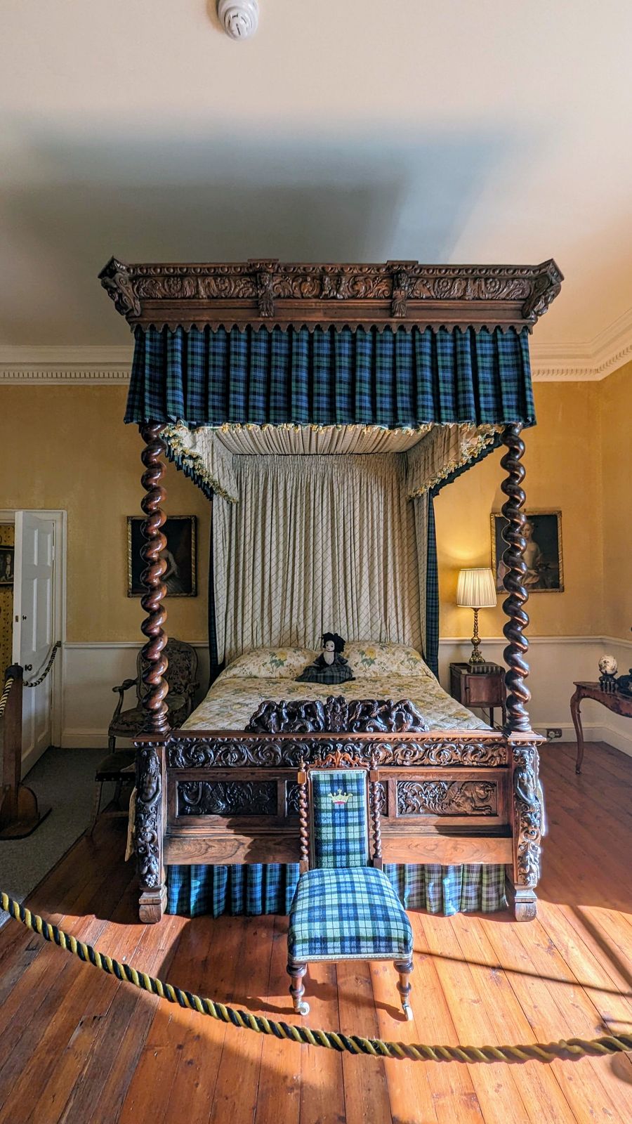 A tartan-draped four-poster bed in a state bedroom at Inveraray Castle