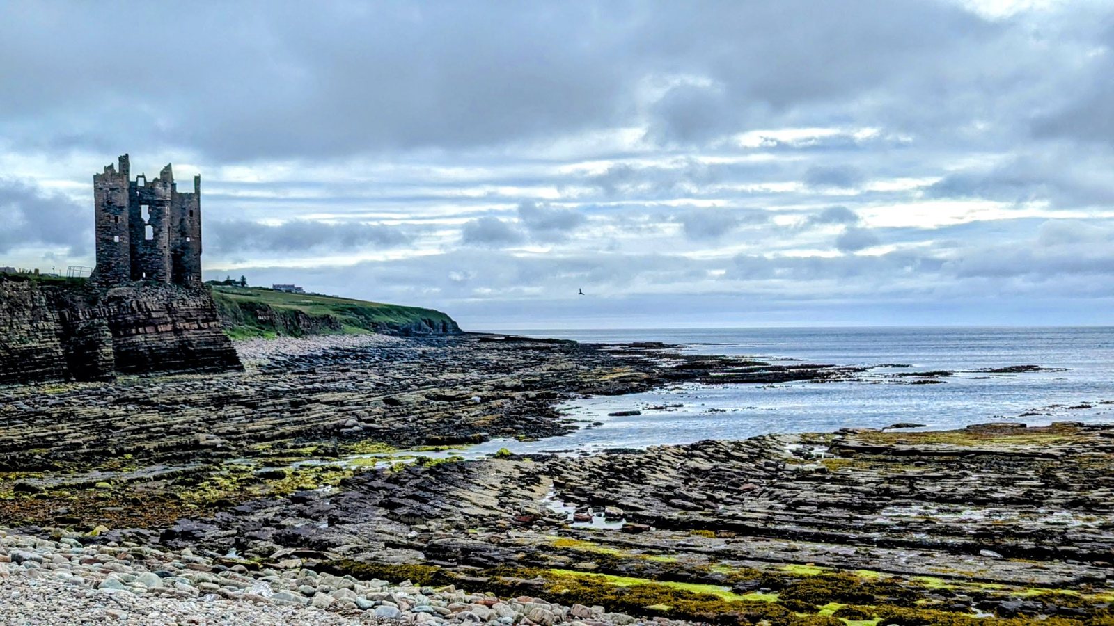 The ruined tower of old Keiss Castle on its clifftop stack above Sinclair&rsquo;s Bay, Caithness, under a moody sky.