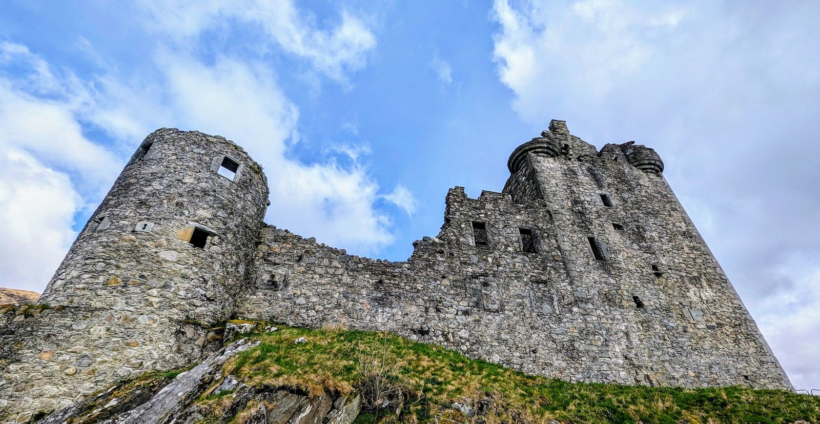 The path up to the ruins of Kilchurn Castle with Lillie the dog, the tower rising ahead.