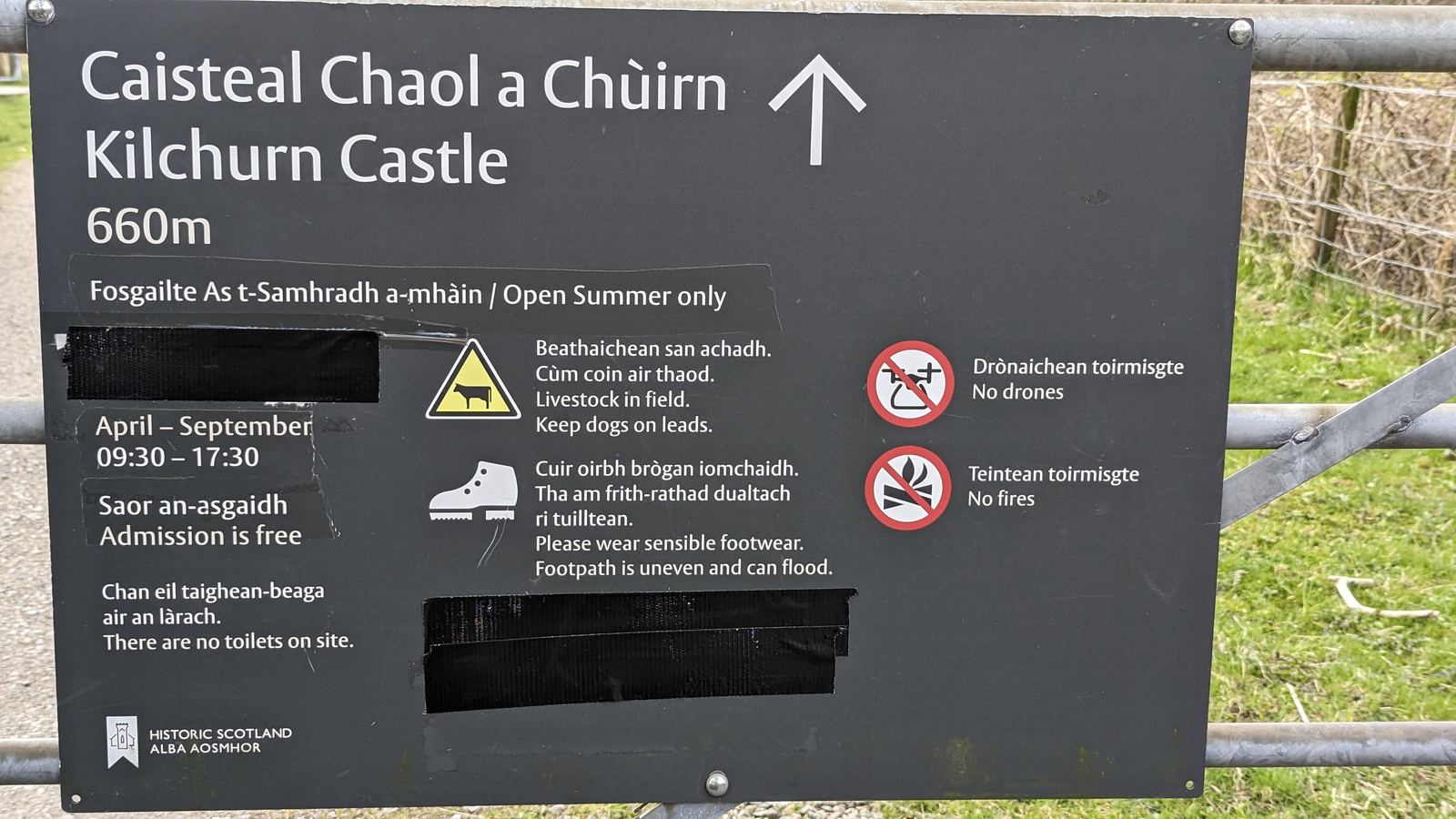 The bilingual Gaelic and English footpath sign to Kilchurn Castle, open in summer only.