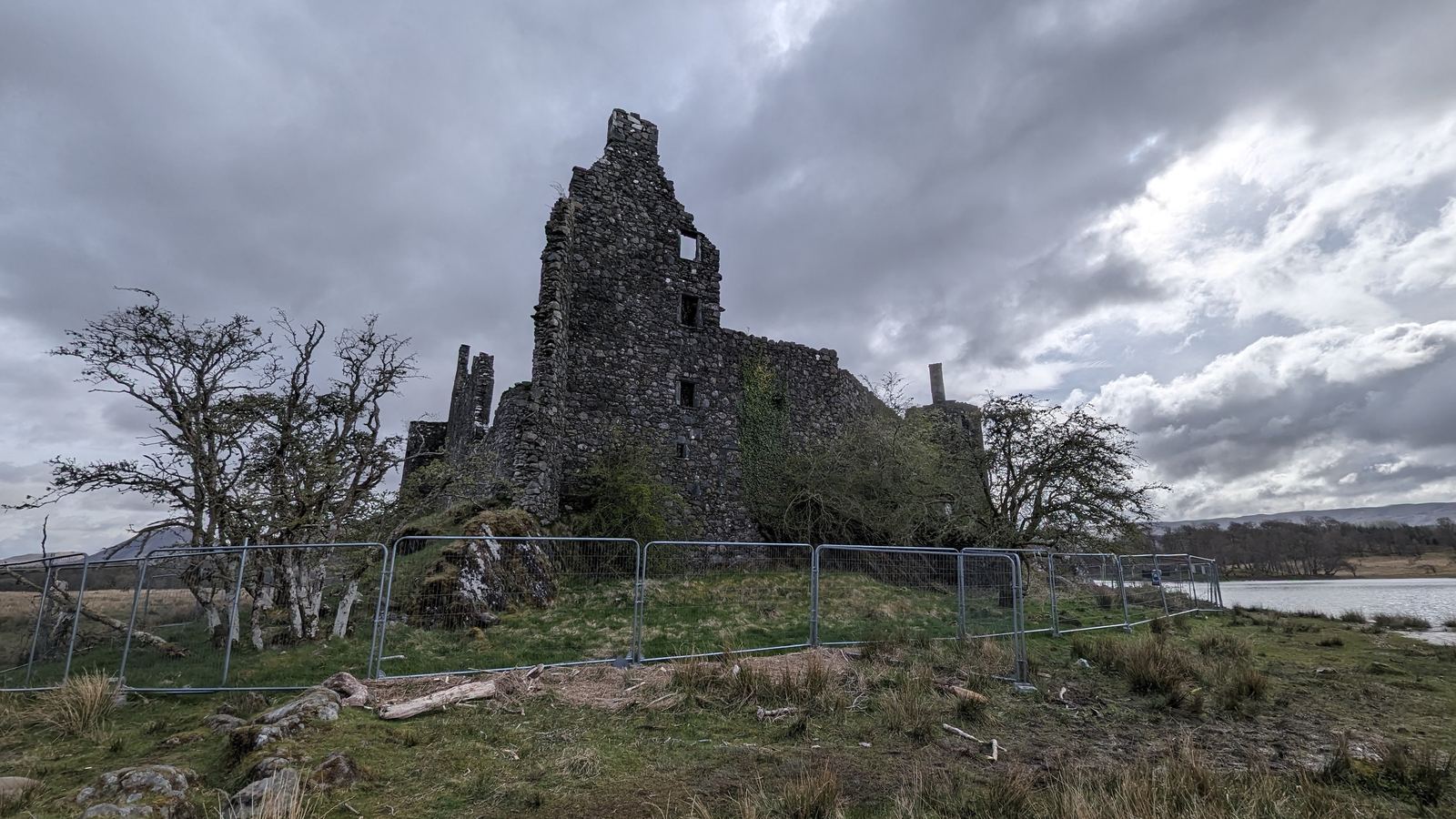 The roofless stone ruins of Kilchurn Castle up close, tower and walls against the sky.