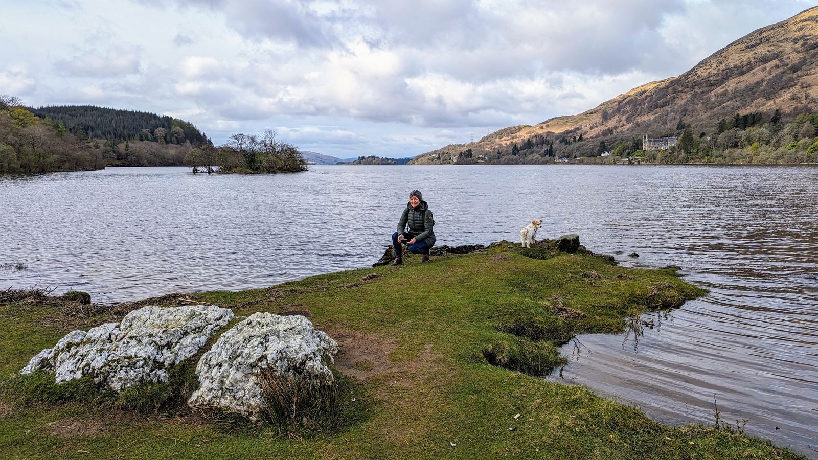 Kevin and Lillie the dog sitting by the shore of Loch Awe near Kilchurn Castle.