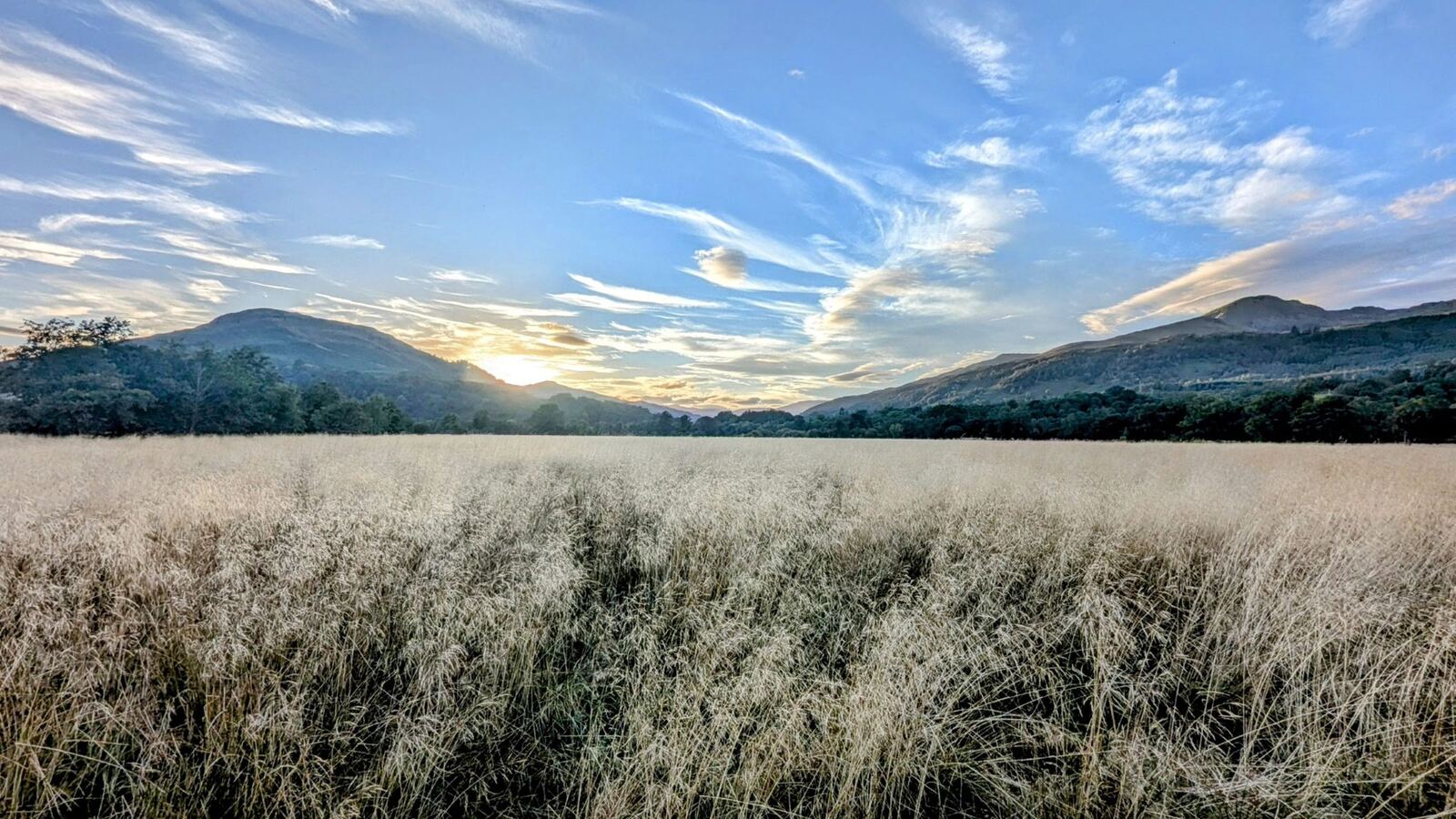 A still, misty dawn over the head of Loch Tay near Killin, frosted grass and mountains beyond.