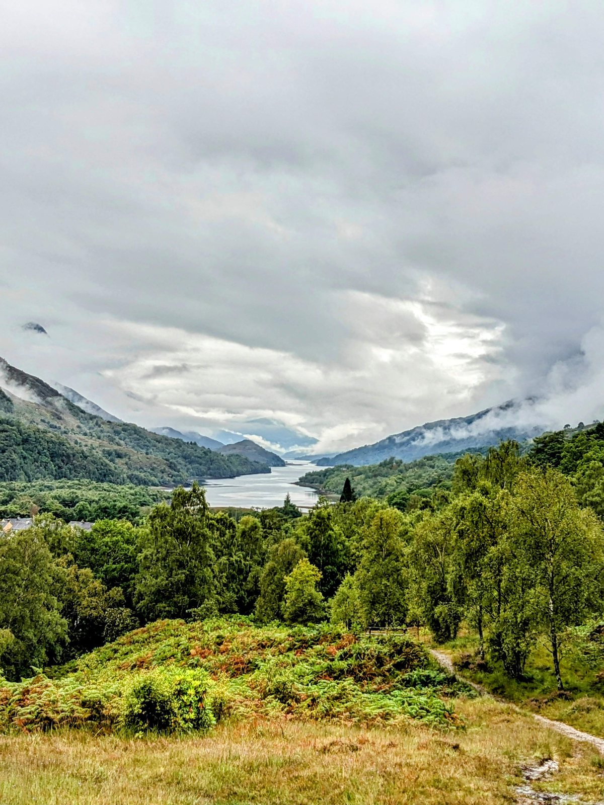 The view down Loch Leven from above Kinlochleven, the sea loch running west into misty mountains.