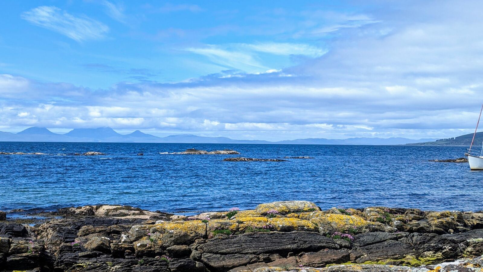 The blue Kilbrannan Sound with the mountains of Arran on the horizon, seen from the east Kintyre shore.