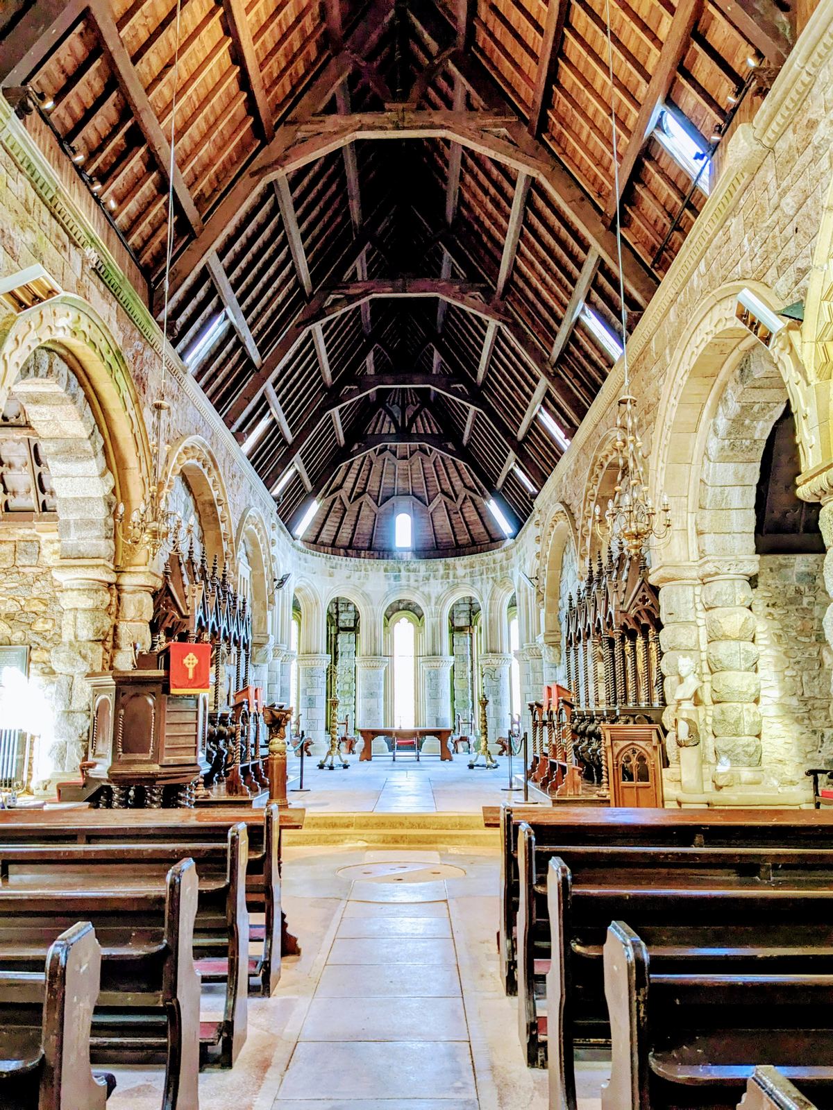 The Romanesque nave of St Conan&rsquo;s Kirk, timber roof and stone arches.