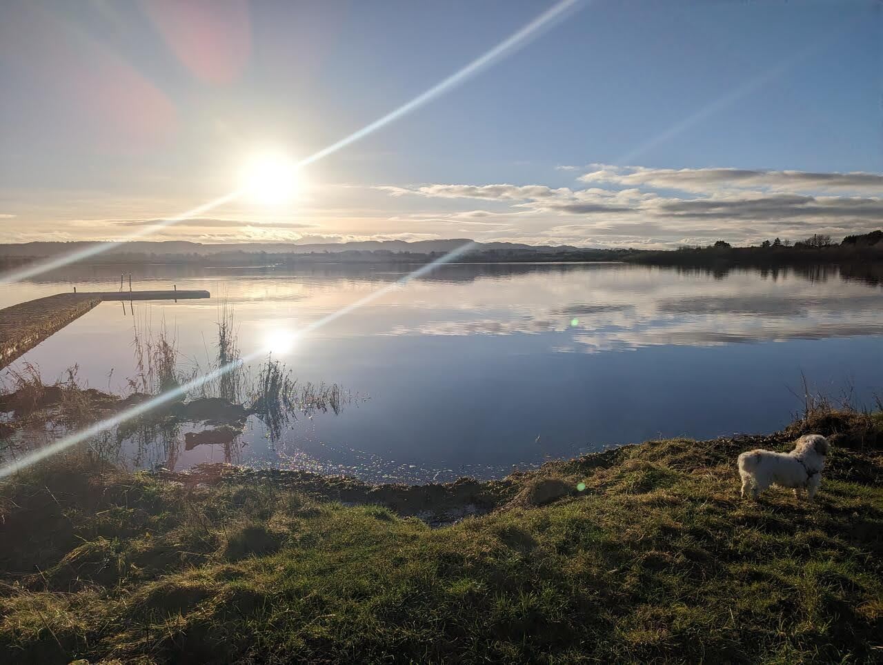 Sunrise over Loch Leven with a jetty and mirror-calm reflections