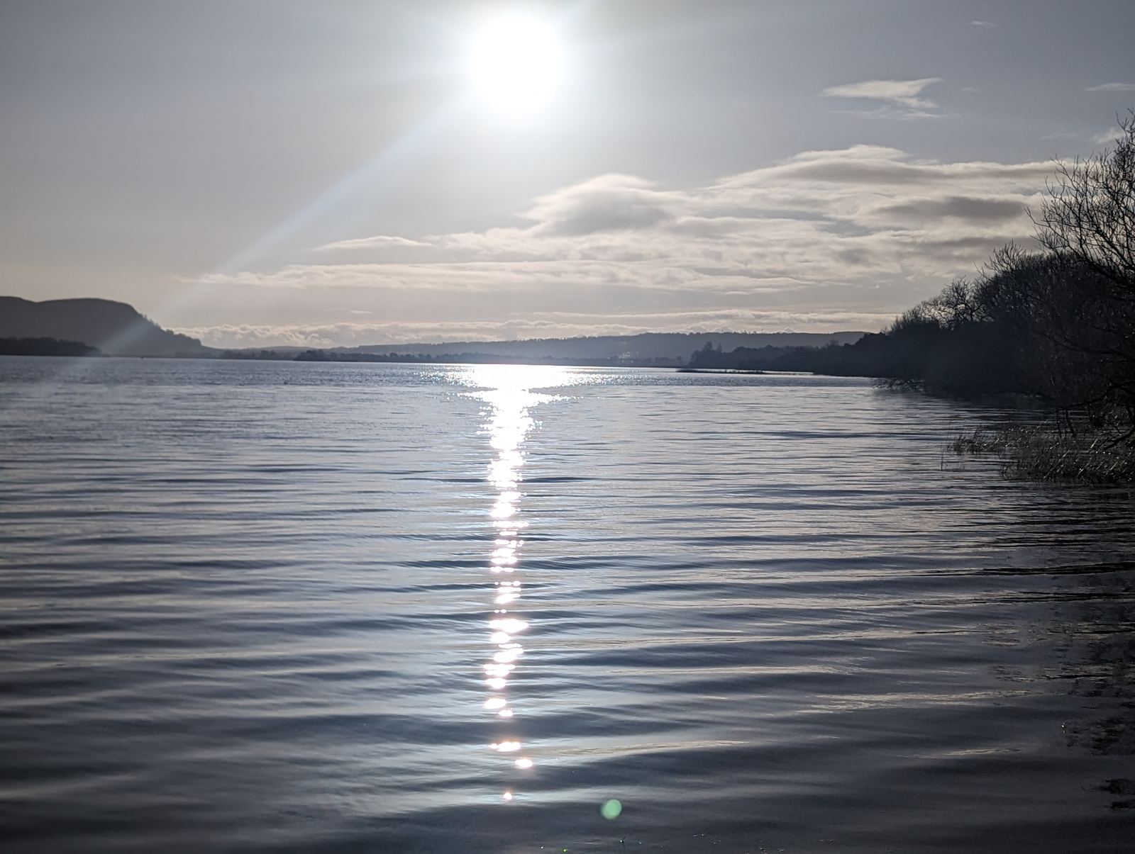 The sun laying a path of light across Loch Leven at dusk