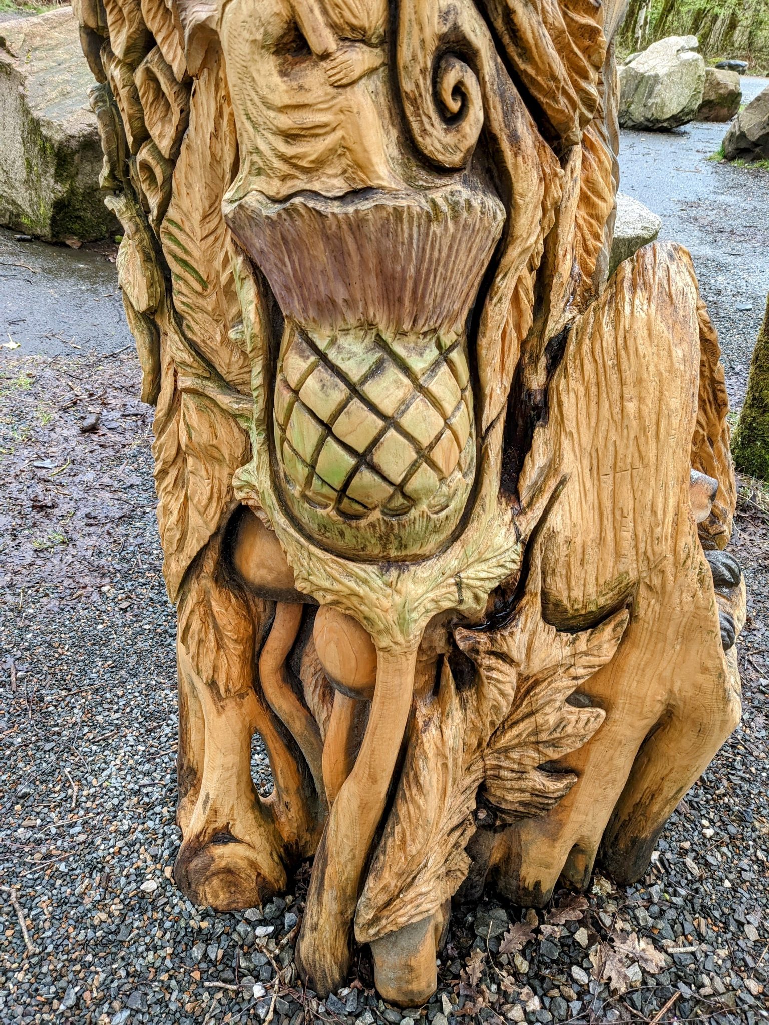 A large carved wooden Scottish thistle sculpture on the Loch Lomond fairy trail at Luss.