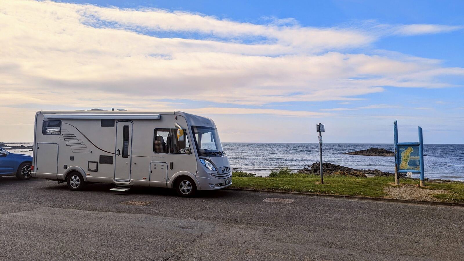 A white Hymer motorhome parked by the shore at Machrihanish with the sea and evening sky behind.