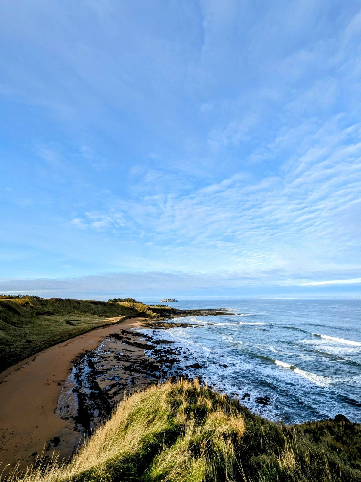 A panorama of the North Berwick coast in winter, sweeping sands and rocky points under a big sky.