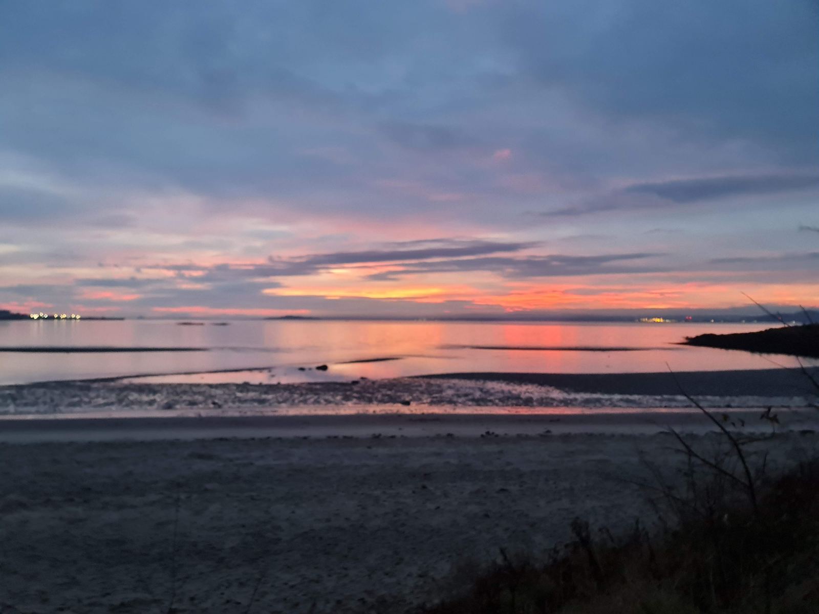 Winter sunrise over the wide sands and mudflats of the North Berwick coast, pink and gold sky.