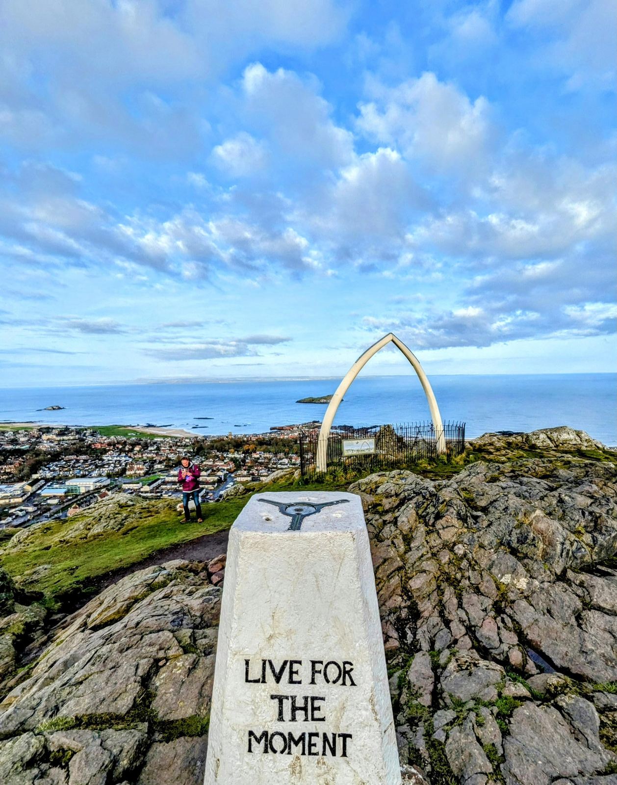 The whale-jawbone arch and trig point on North Berwick Law, the town of North Berwick spread out below.