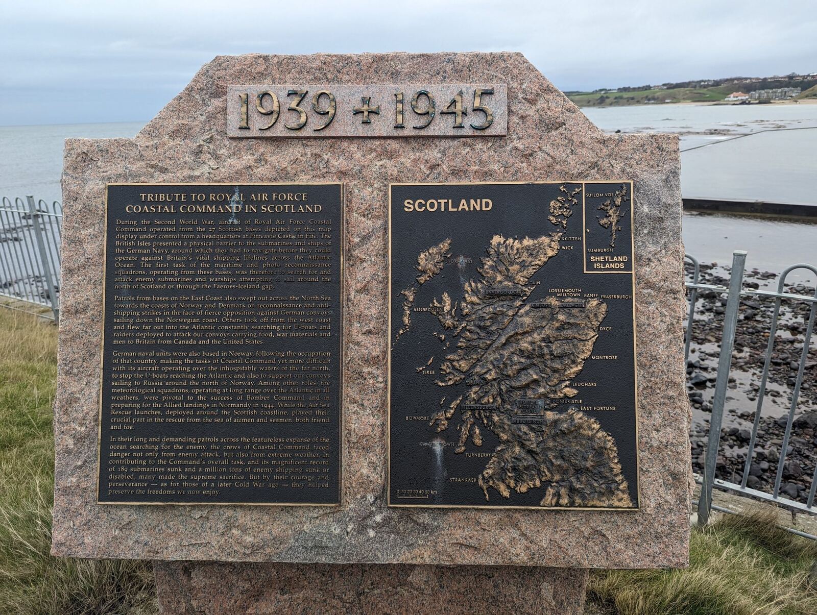 Granite memorial inscribed '1939 1945' with a bronze relief map of Scotland, a tribute to RAF Coastal Command, on the North Berwick shore.
