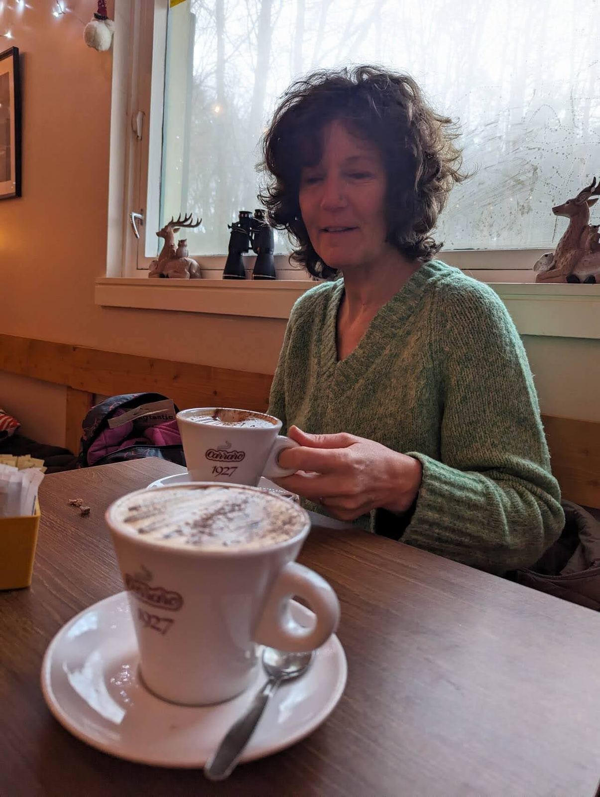 A woman with a cappuccino in the dog-friendly Pentland Hills Cafe at Flotterstone.