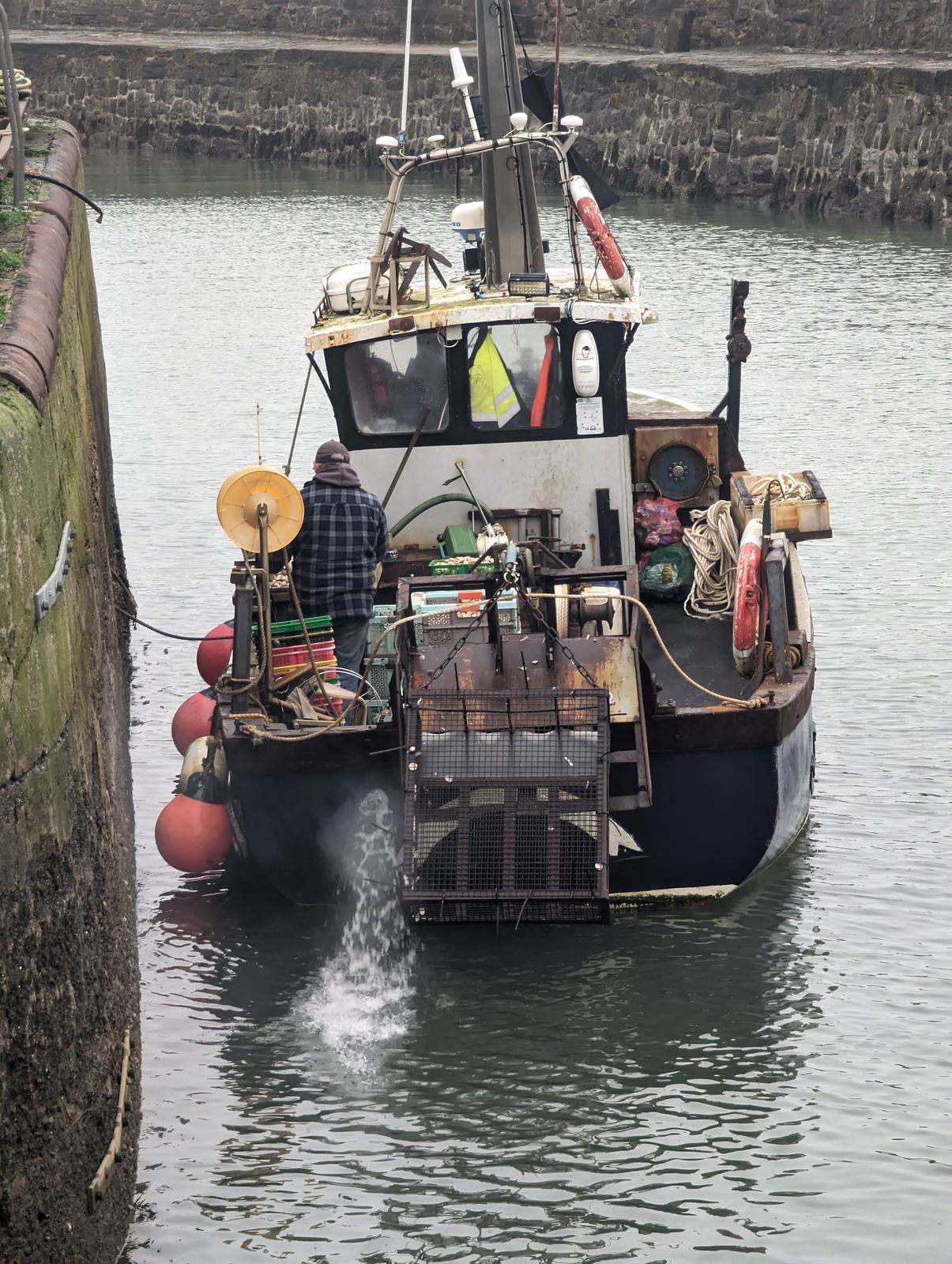 A fisherman working the deck as his boat comes into Pittenweem