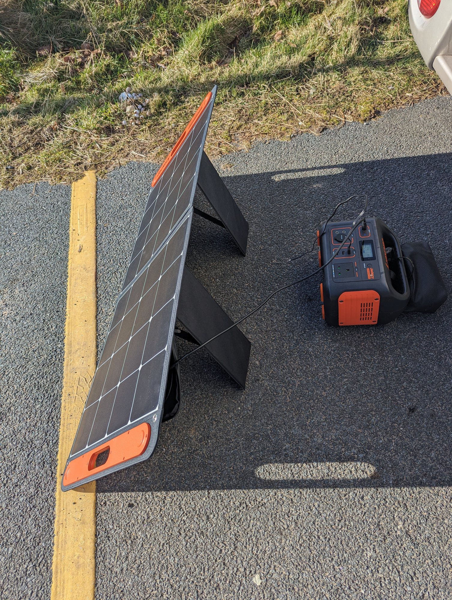 A fold-out solar panel and portable power station set up beside the van in Scotland.