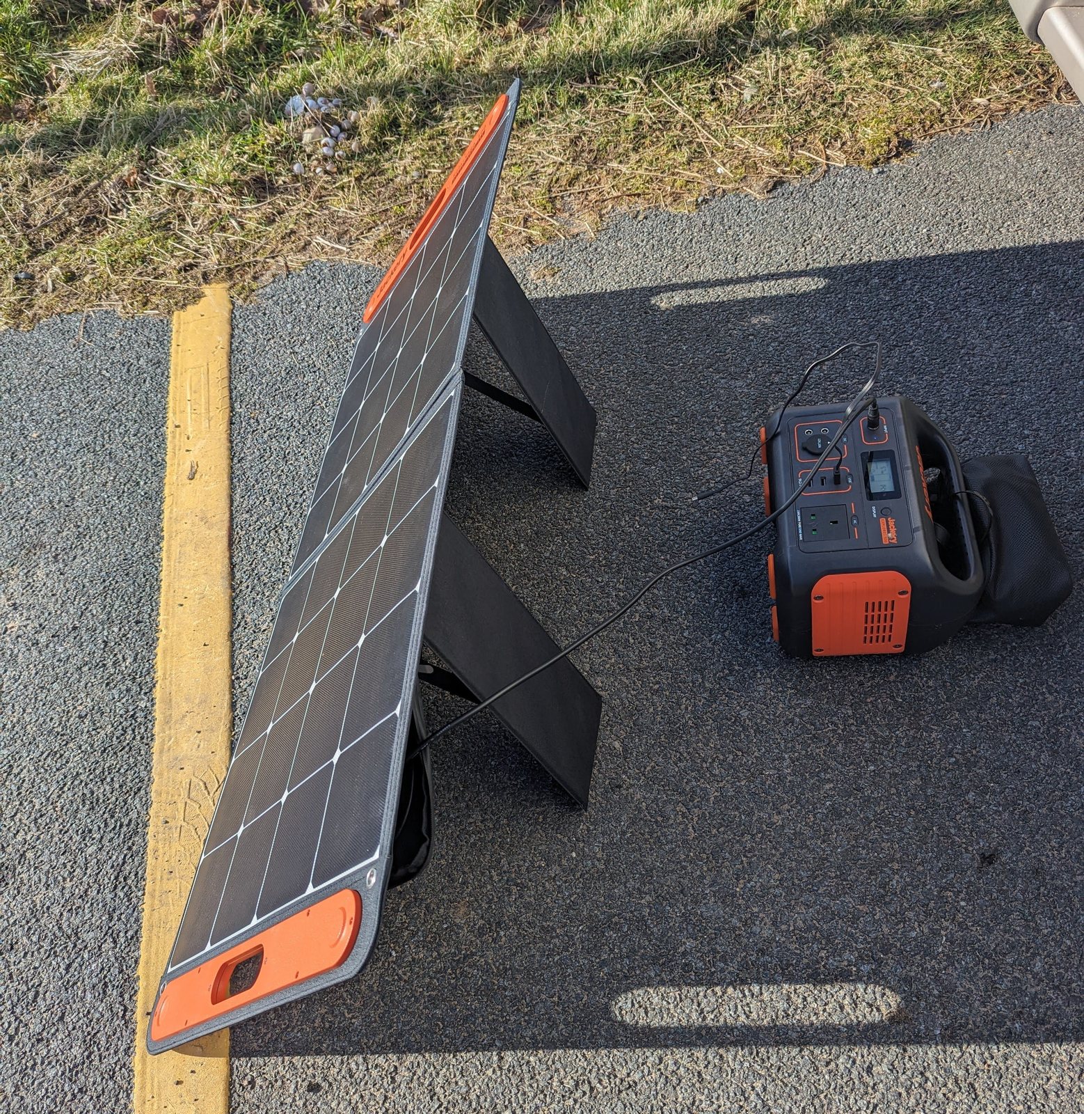 The solar panel angled towards the sun next to the power station.
