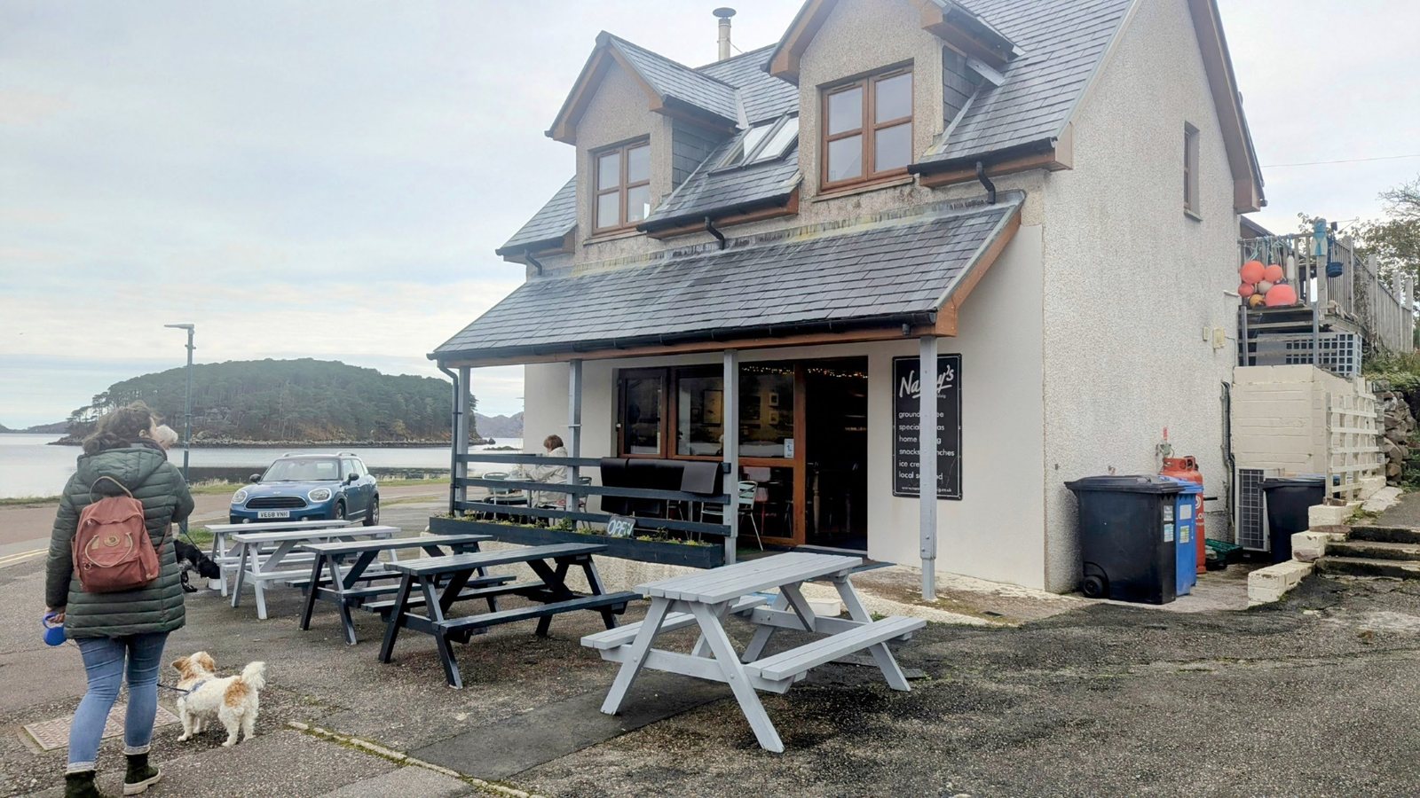 A cafe with outdoor tables at Shieldaig, Lillie the dog nearby.