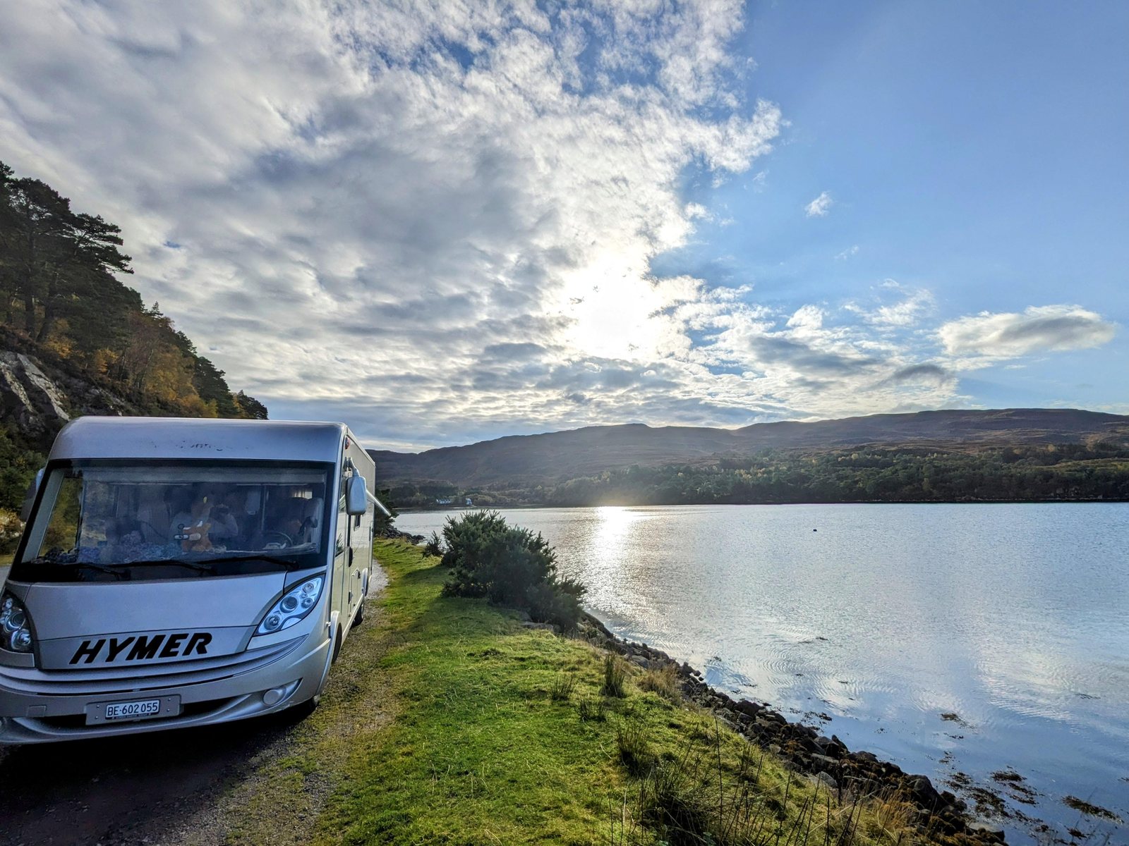 A motorhome parked by Loch Shieldaig at sunset.
