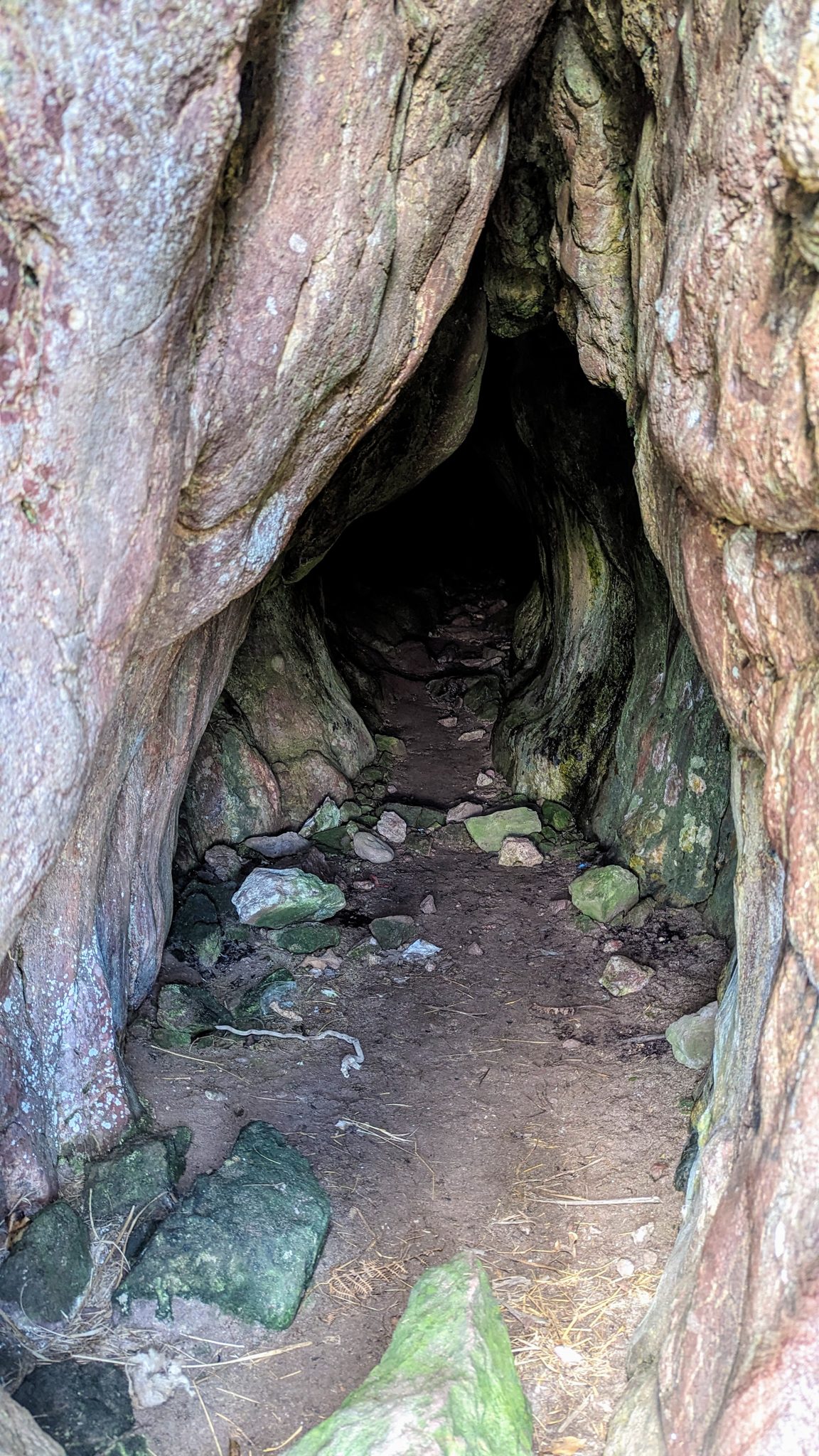 The dark rocky mouth of Keil Cave in the cliff near Southend, Kintyre.
