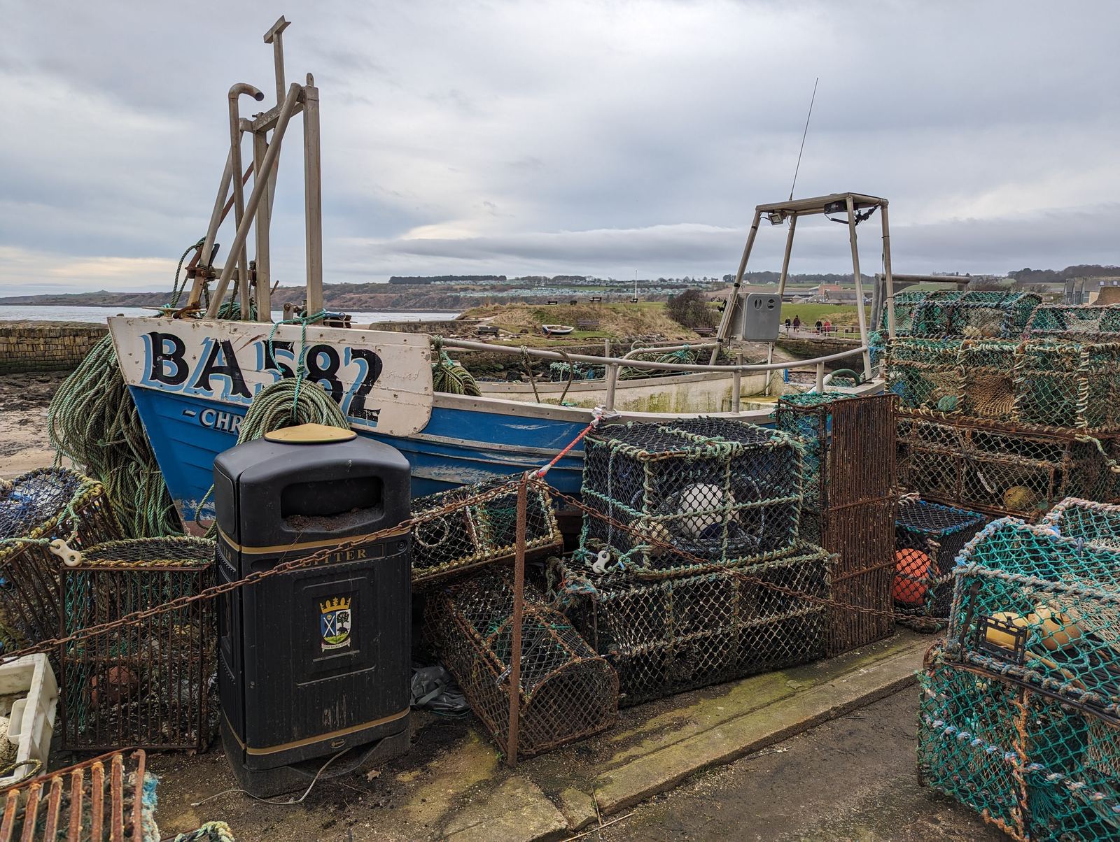 A fishing boat and stacked creels at St Andrews harbour.